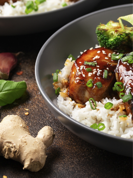 rôti de porc à la chinoise nappé de sauce brillante, servi avec du riz et des légumes dans un bol