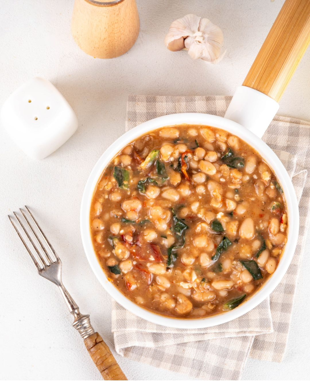 Bol de haricots blancs mijotés dans une sauce tomate aux épinards