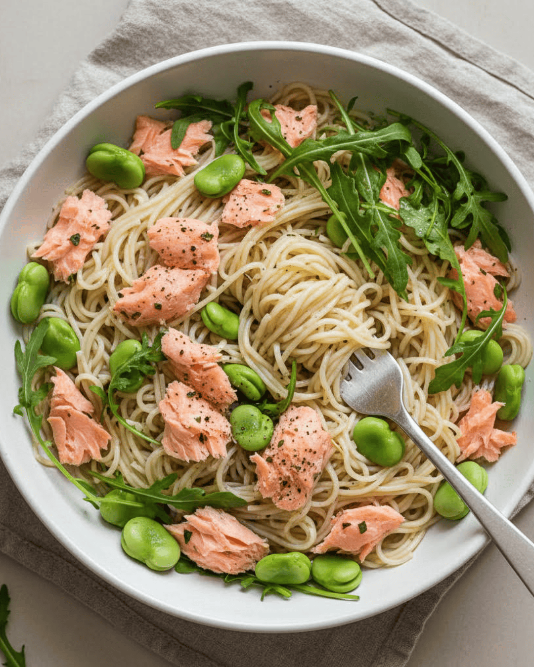 Nouilles de riz au saumon, fèves et citron dans une assiette.