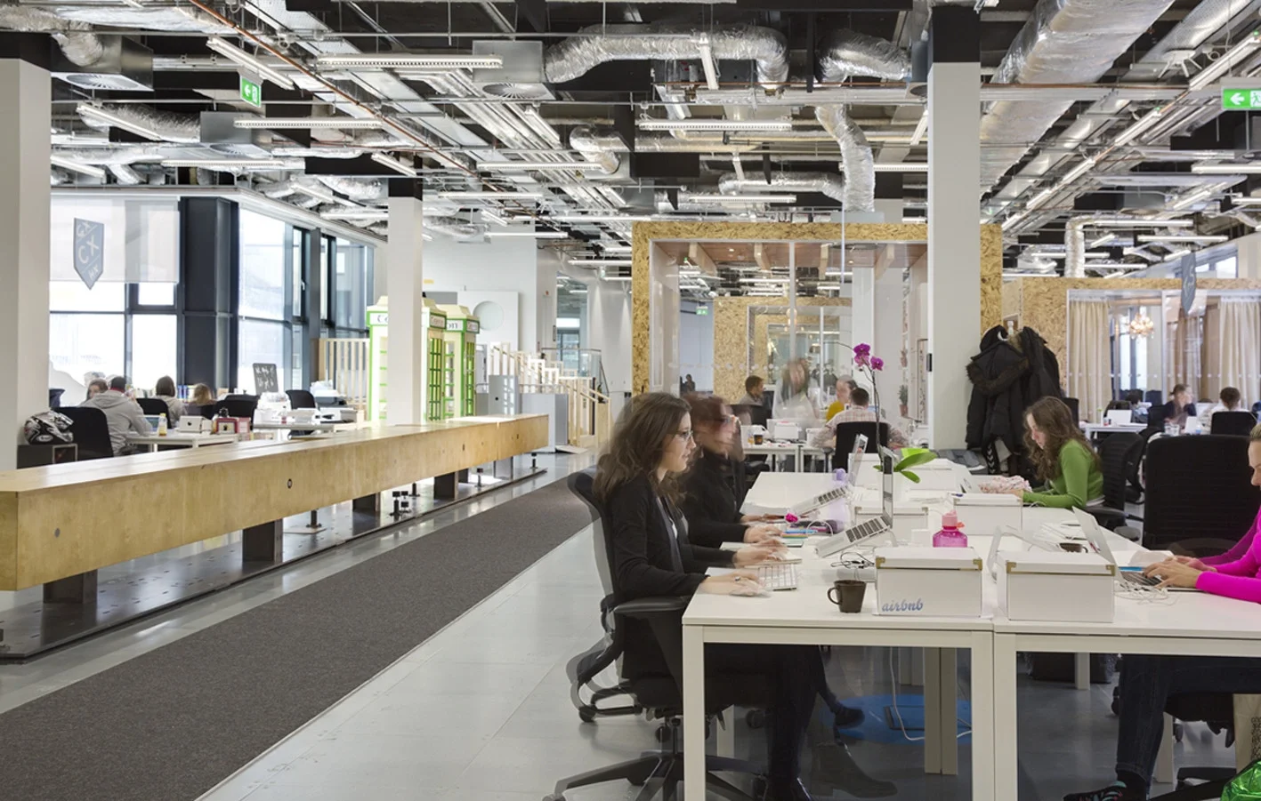 Open plan workplace interior with many employees working and talking, illustrating how noise spreads across modern office environments.