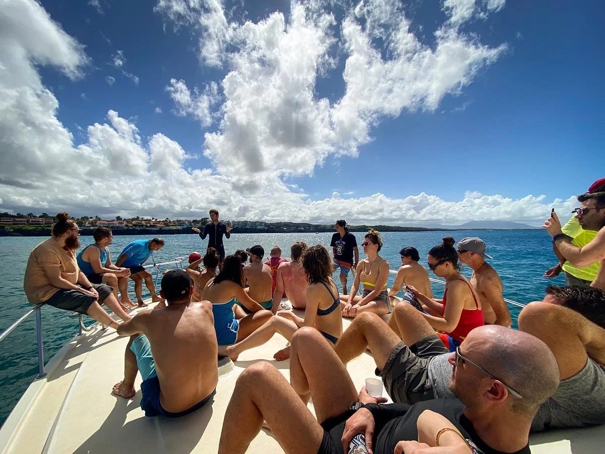 Man with hat and red shirt planting a mangrove for global coralition