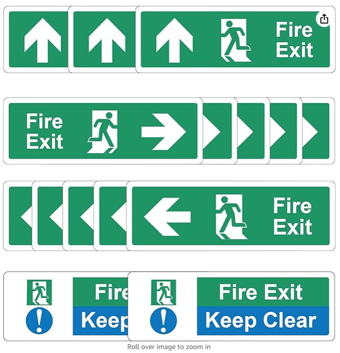 Various green and white fire exit signs with arrows pointing in different directions, including upward, right, left, and "Fire Exit Keep Clear" signs.