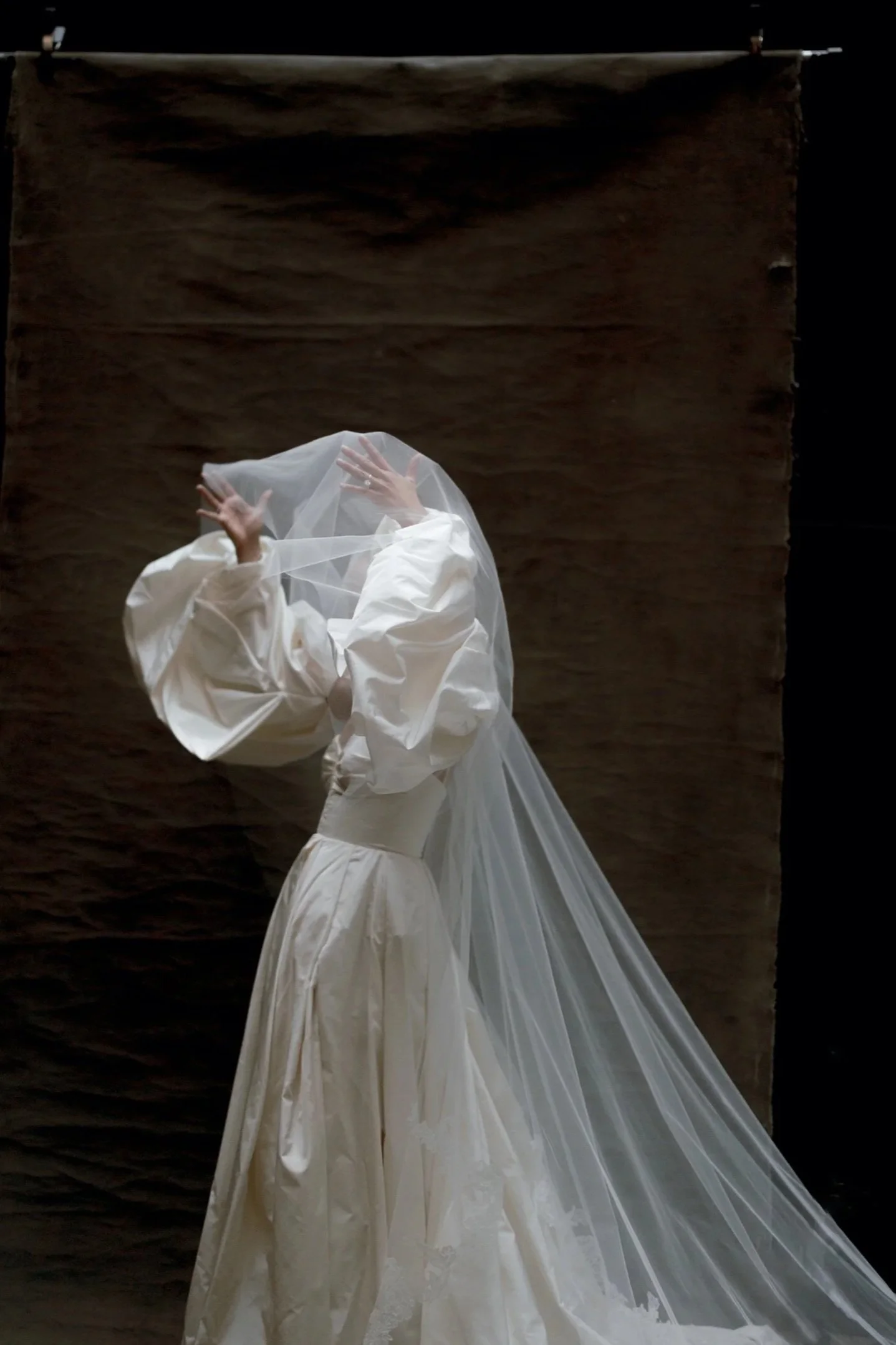 Moments before her wedding ceremony, a bride pulls her blusher over her face.