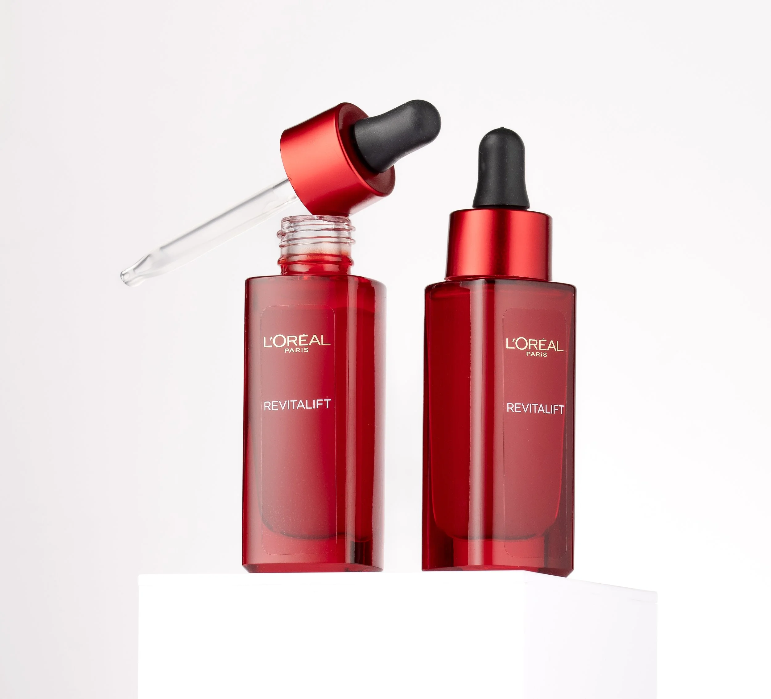 Red L'Oreal Revitalift serum bottles with droppers against a white background.