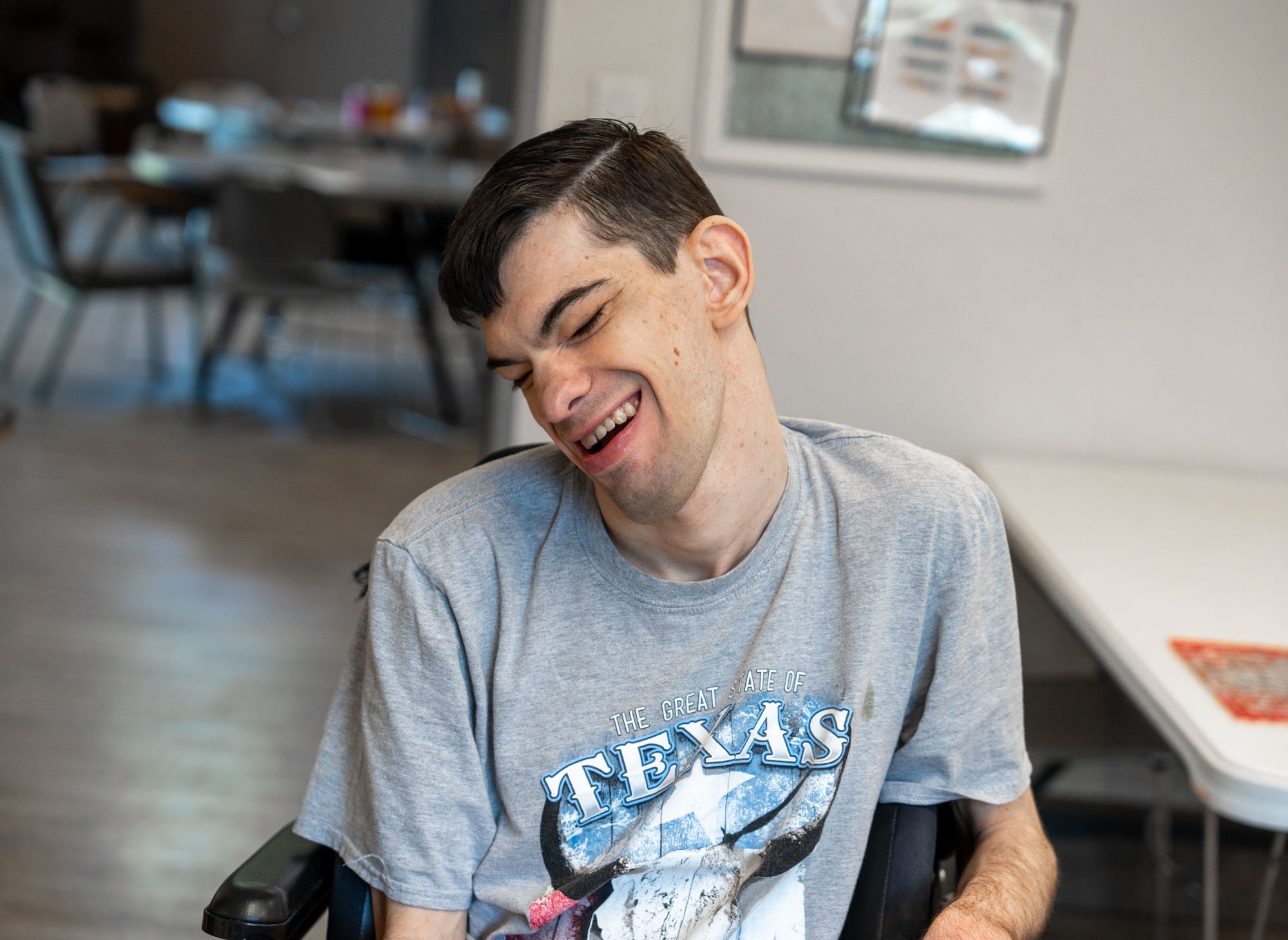 Young-man-in-wheelchair-wearing-Texas-shirt-smiling.jpg