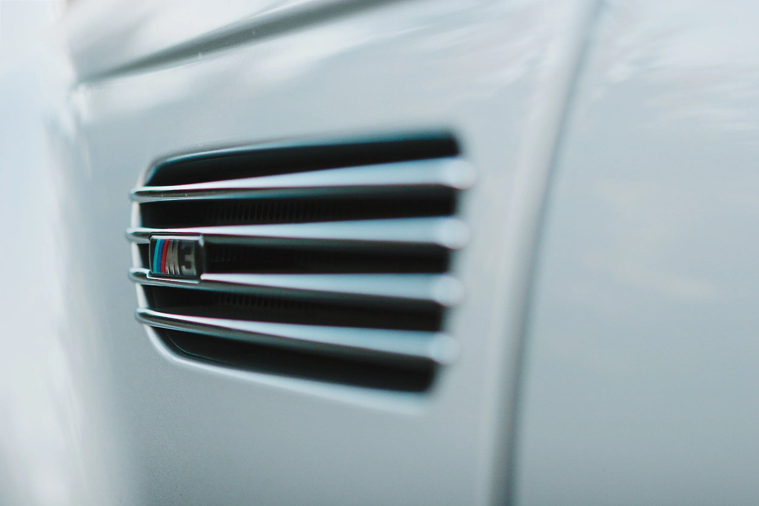 Close-up of BMW M3 car side grille with M badge