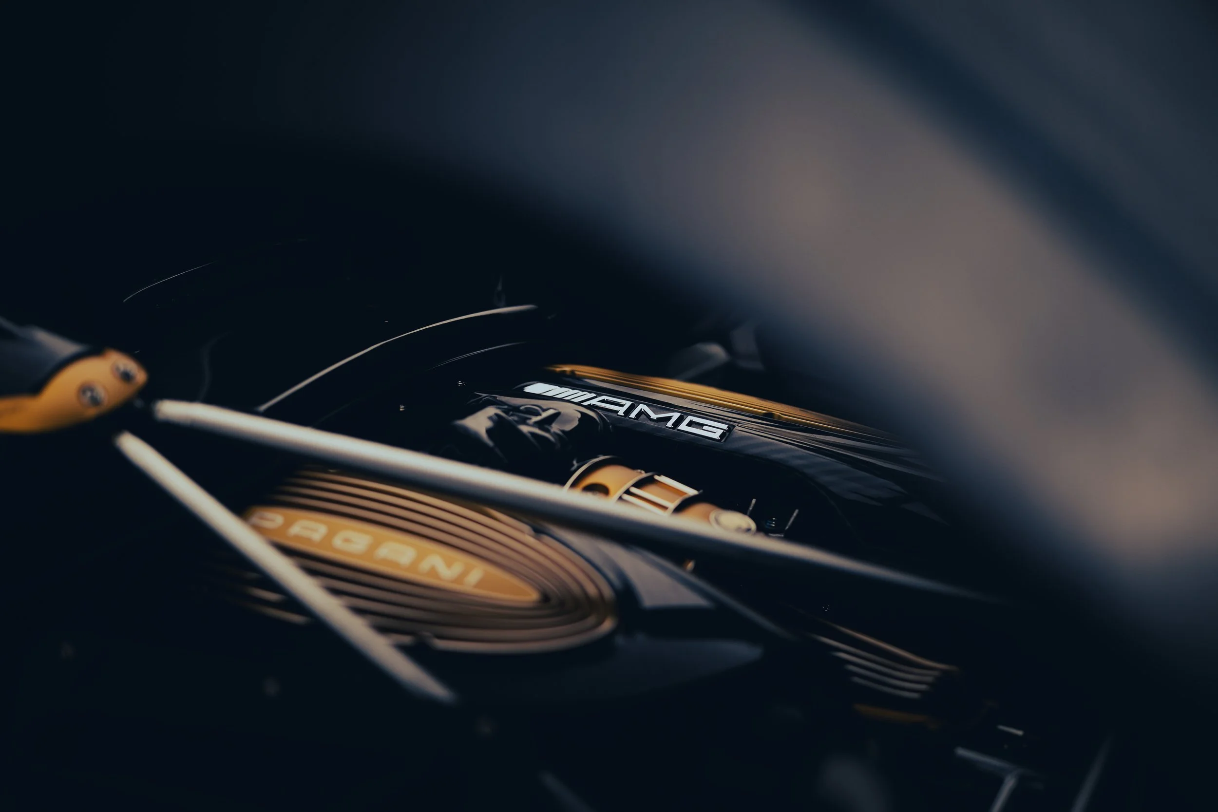 Close-up of a Mercedes-AMG engine with the AMG logo clearly visible, featuring gold accents and metallic details.