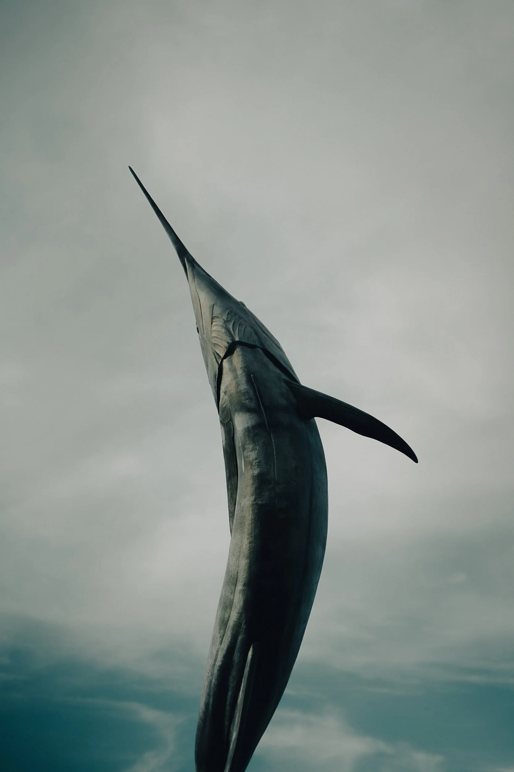 Sculpture of a marlin against a cloudy sky