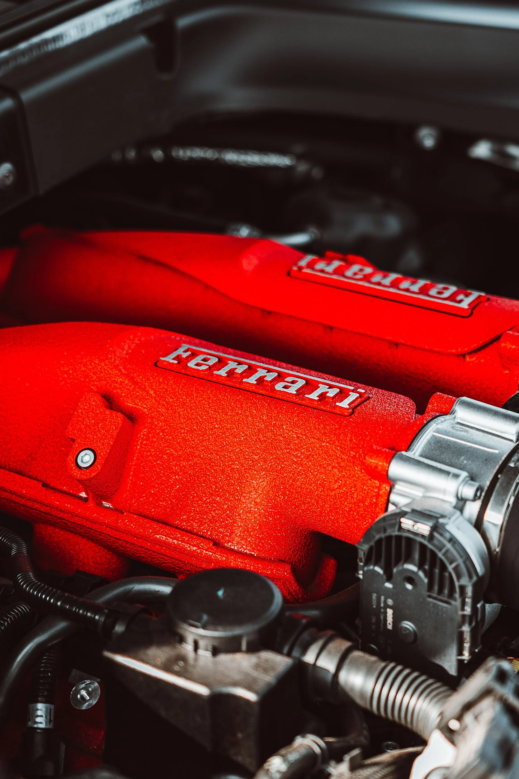 Close-up of a red engine cover with the Ferrari logo.