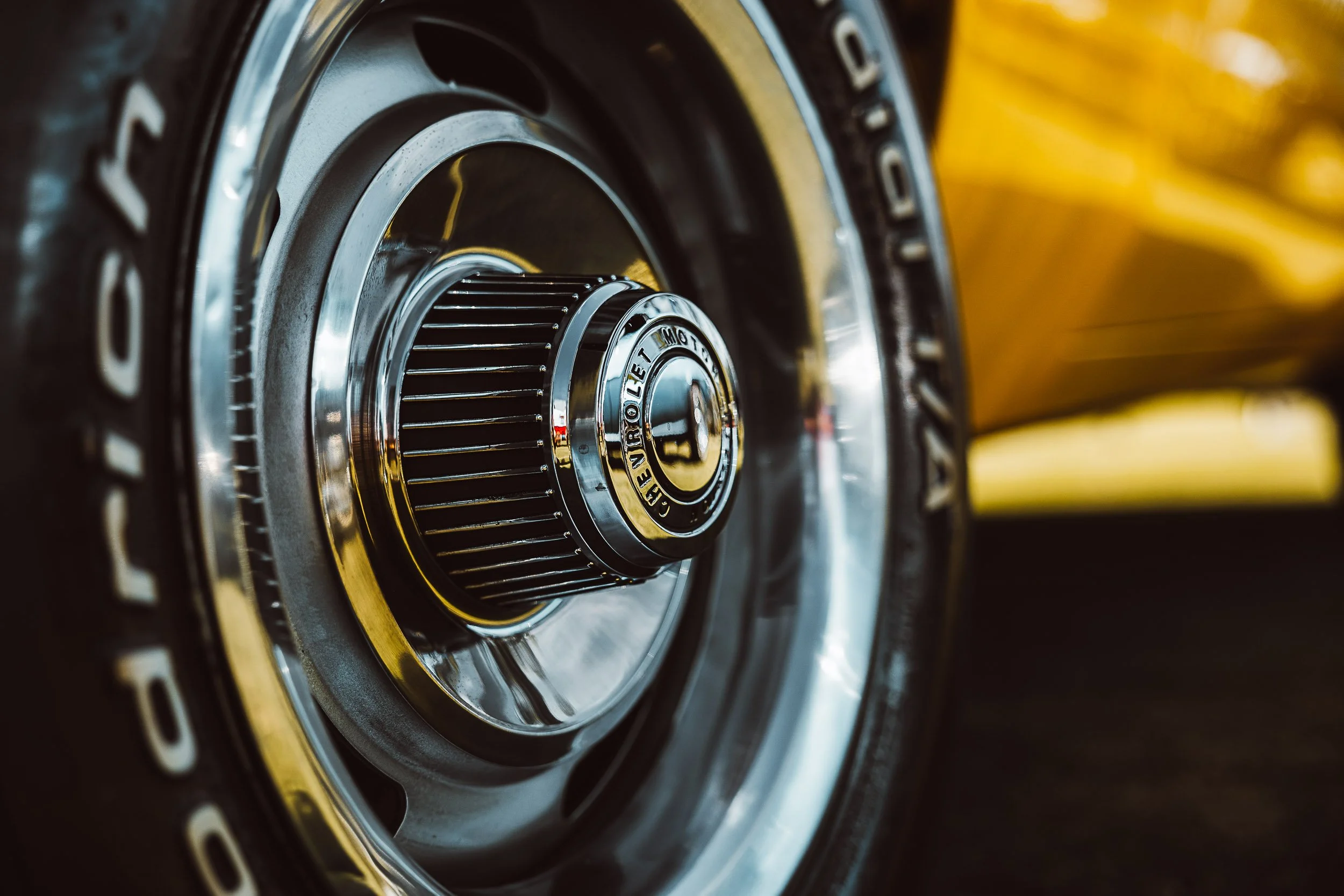 Close-up of a classic car wheel with a Chevrolet hubcap and BF Goodrich tire.