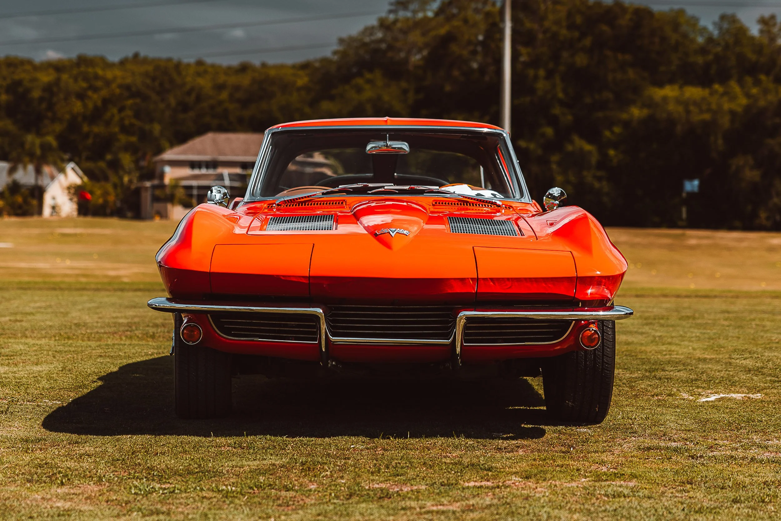 Front view of a vintage red sports car parked on grass