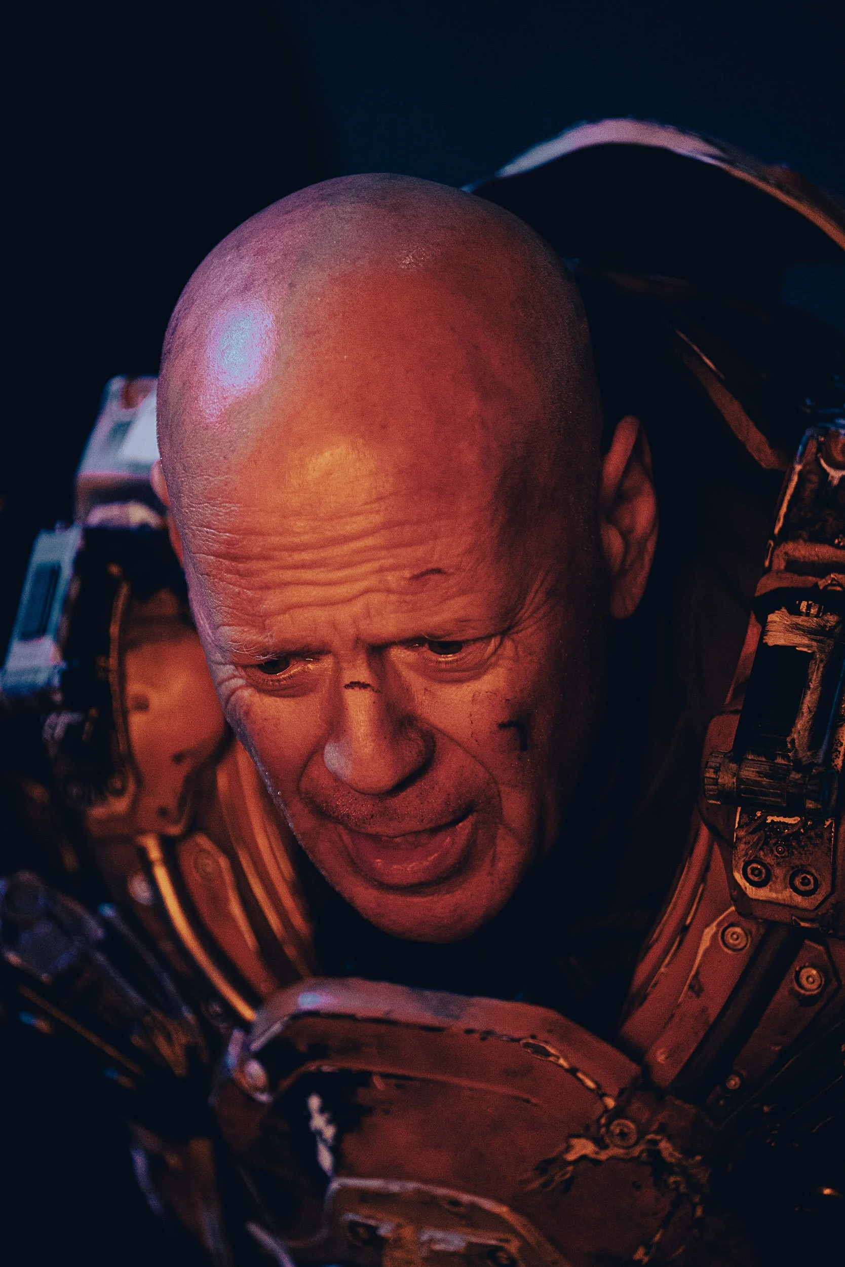 Person wearing a futuristic armored suit with a distressed expression.