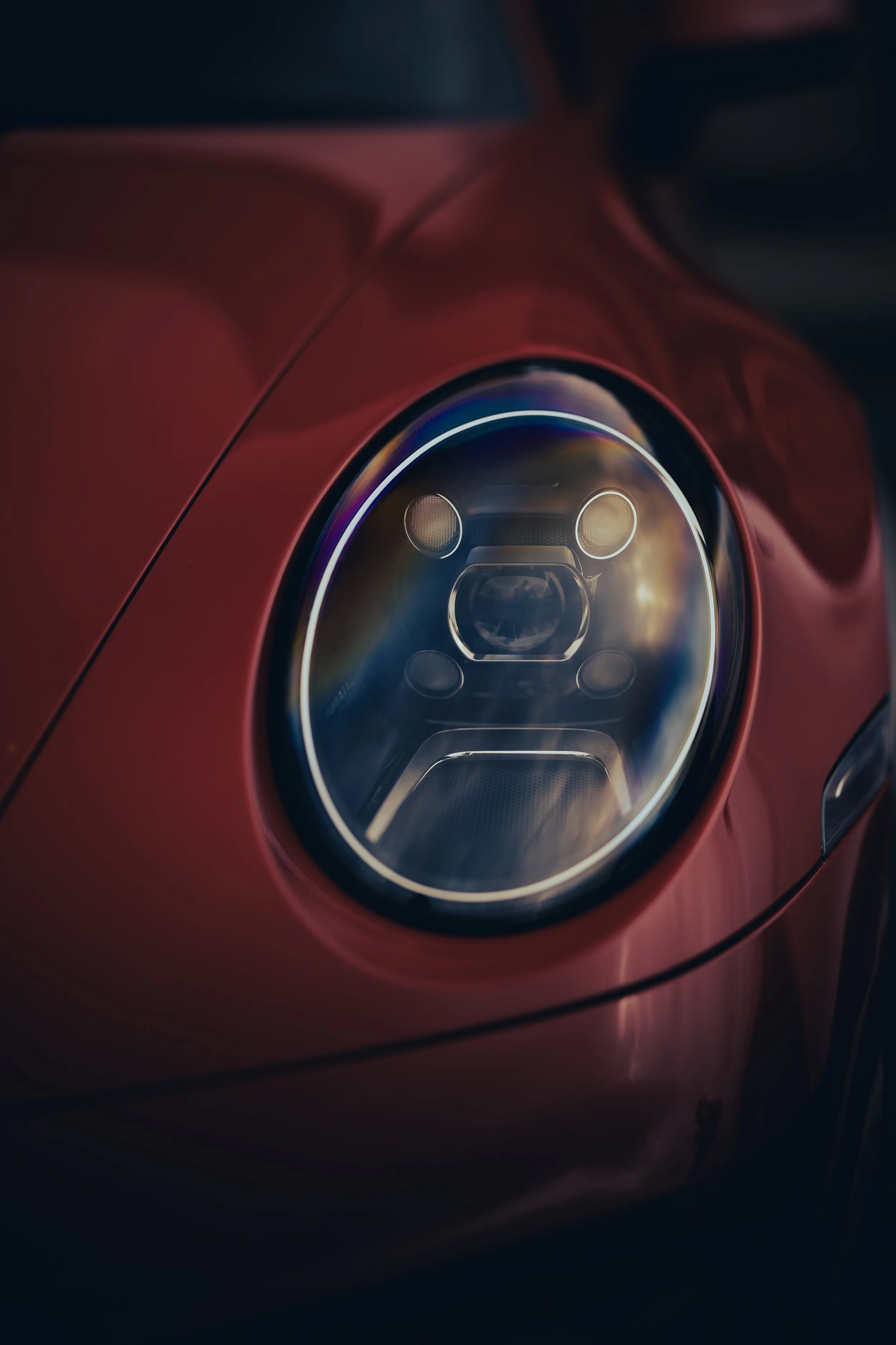 Close-up of a Porsche 911 headlight with modern LED design and surrounding bodywork.