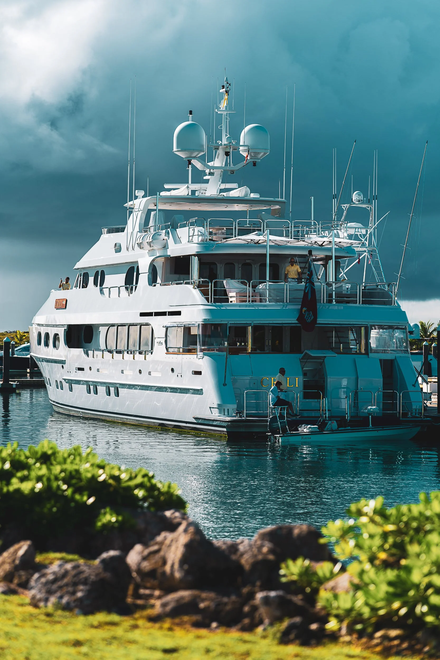 Luxury yacht docked at a marina with cloudy sky