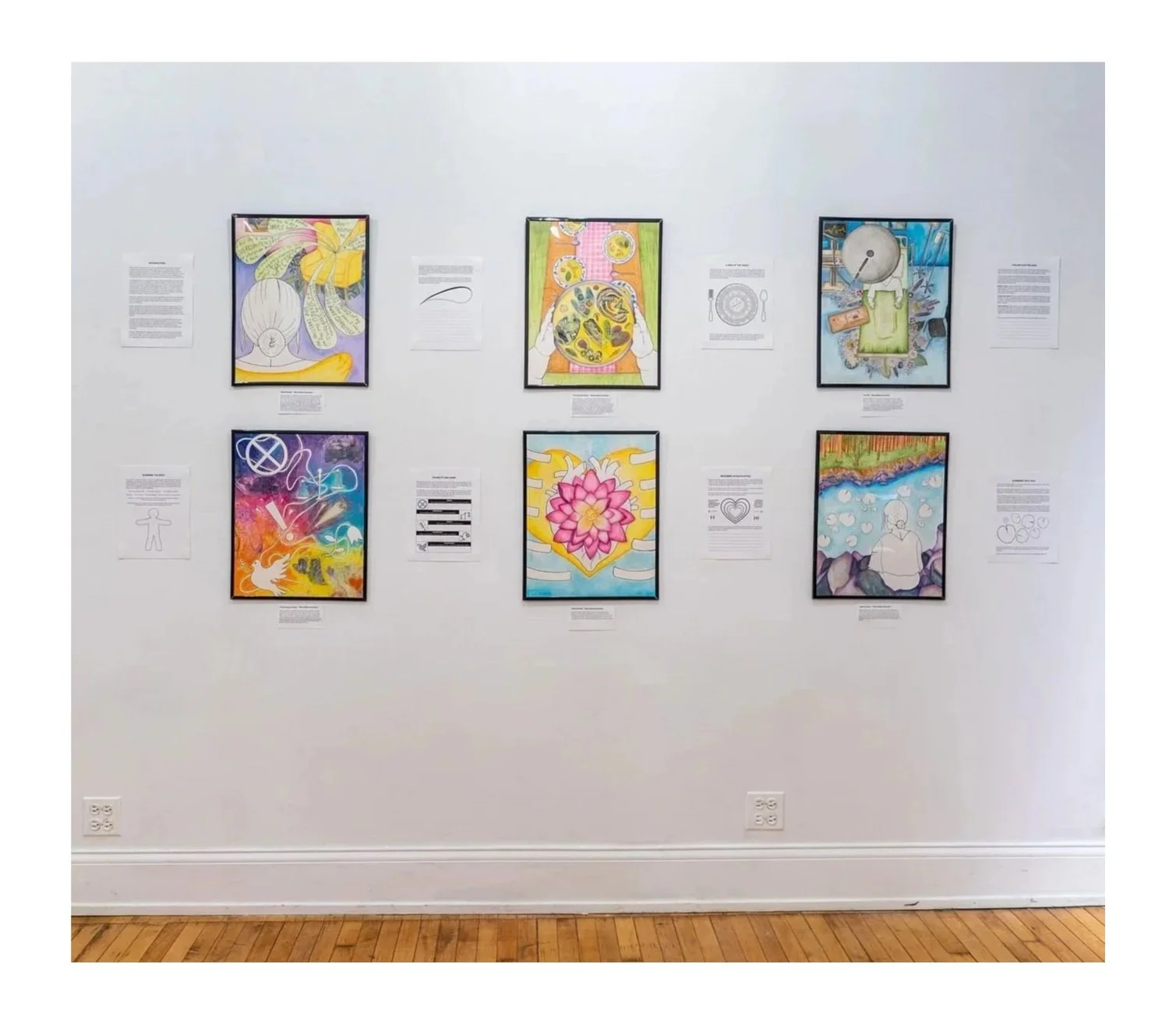 Mixed media artwork display in "[From-Within]" exhibition; Fall 2025; The Center for Mad Culture; Image description: Six (6) framed colorful artworks are displayed on a white wall with wall text surrounding the artwork. 