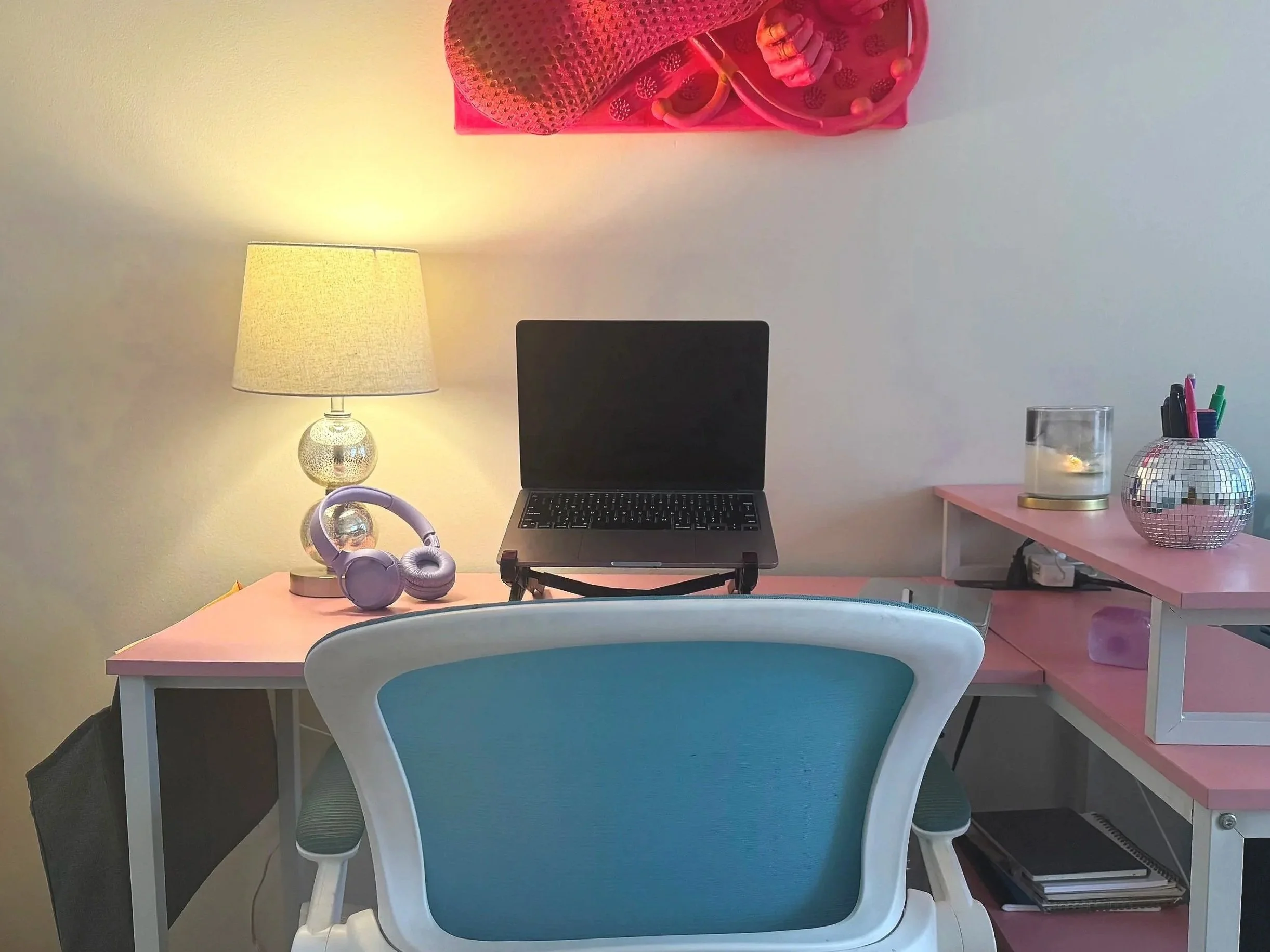 A desk setup with a chair and a laptop