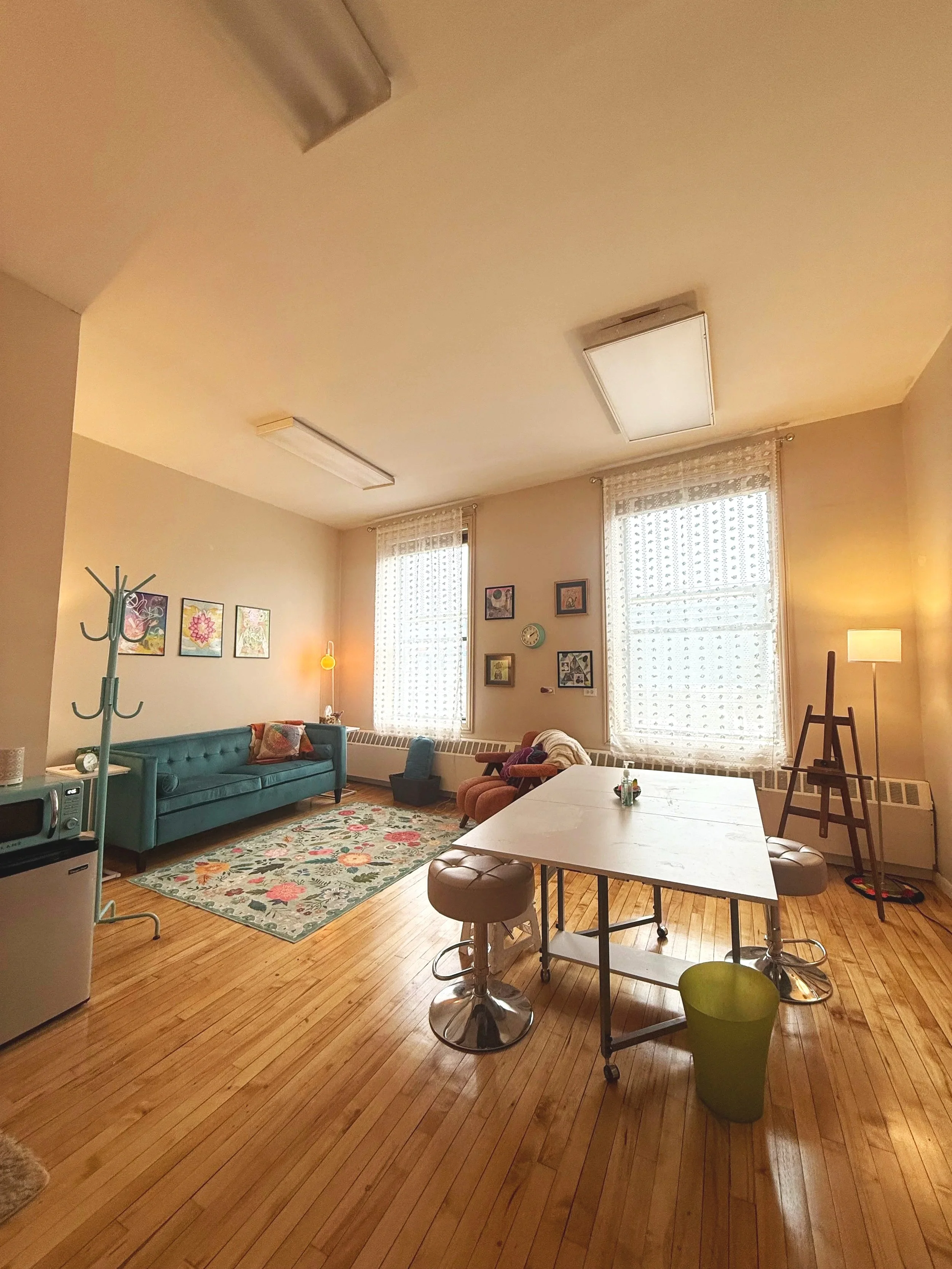 Bri's therapy office showing a couch, chair, and table with stools.