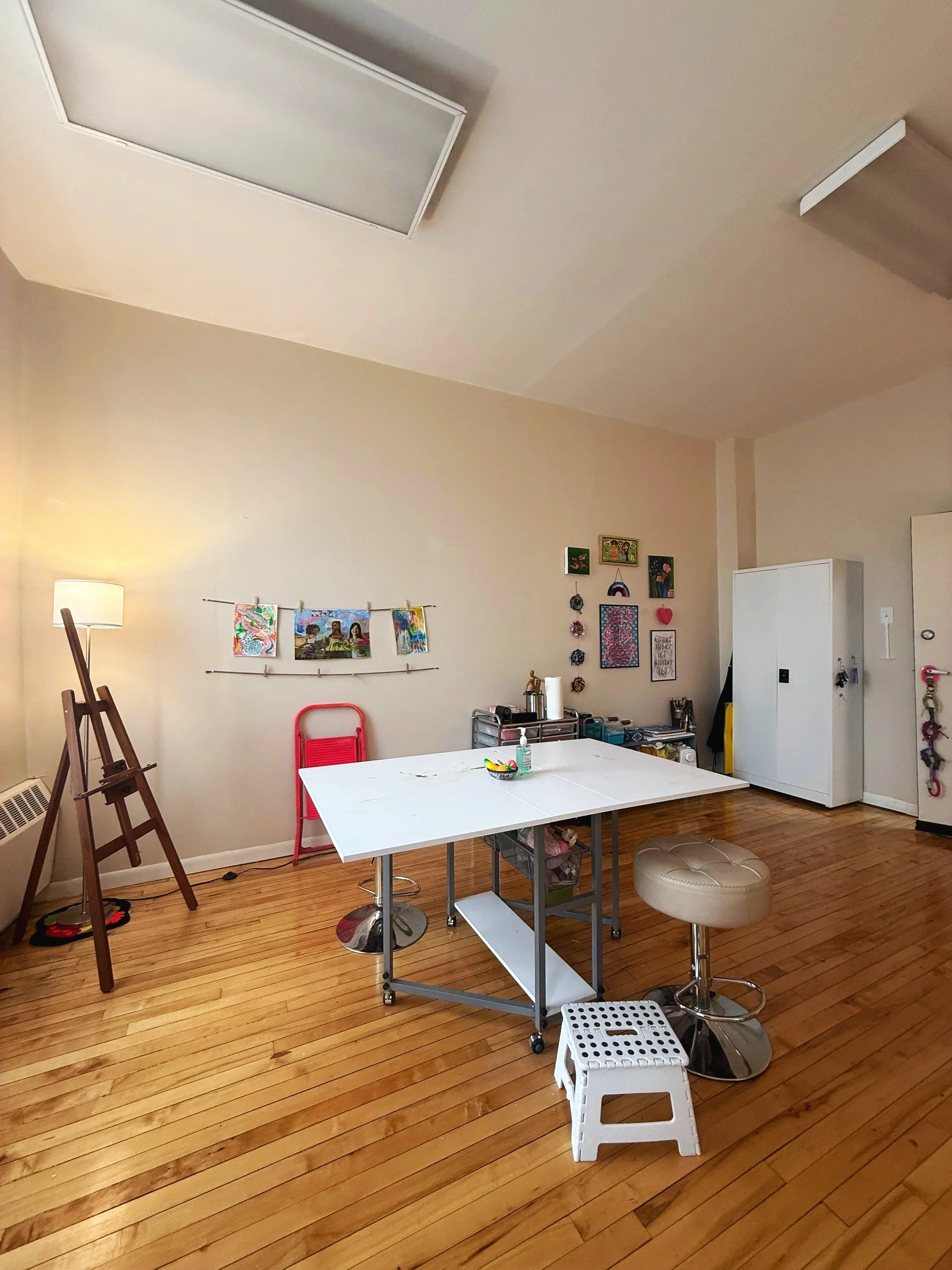 Bri's therapy office showing a table with stools, an easel, and drawers with art supplies