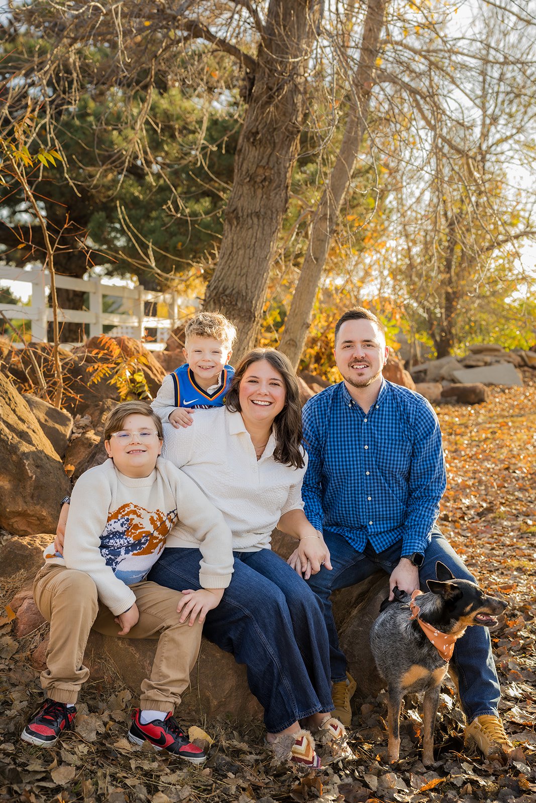 Family sitting together at sunset during their fall mini session with Mel Drake Photography
