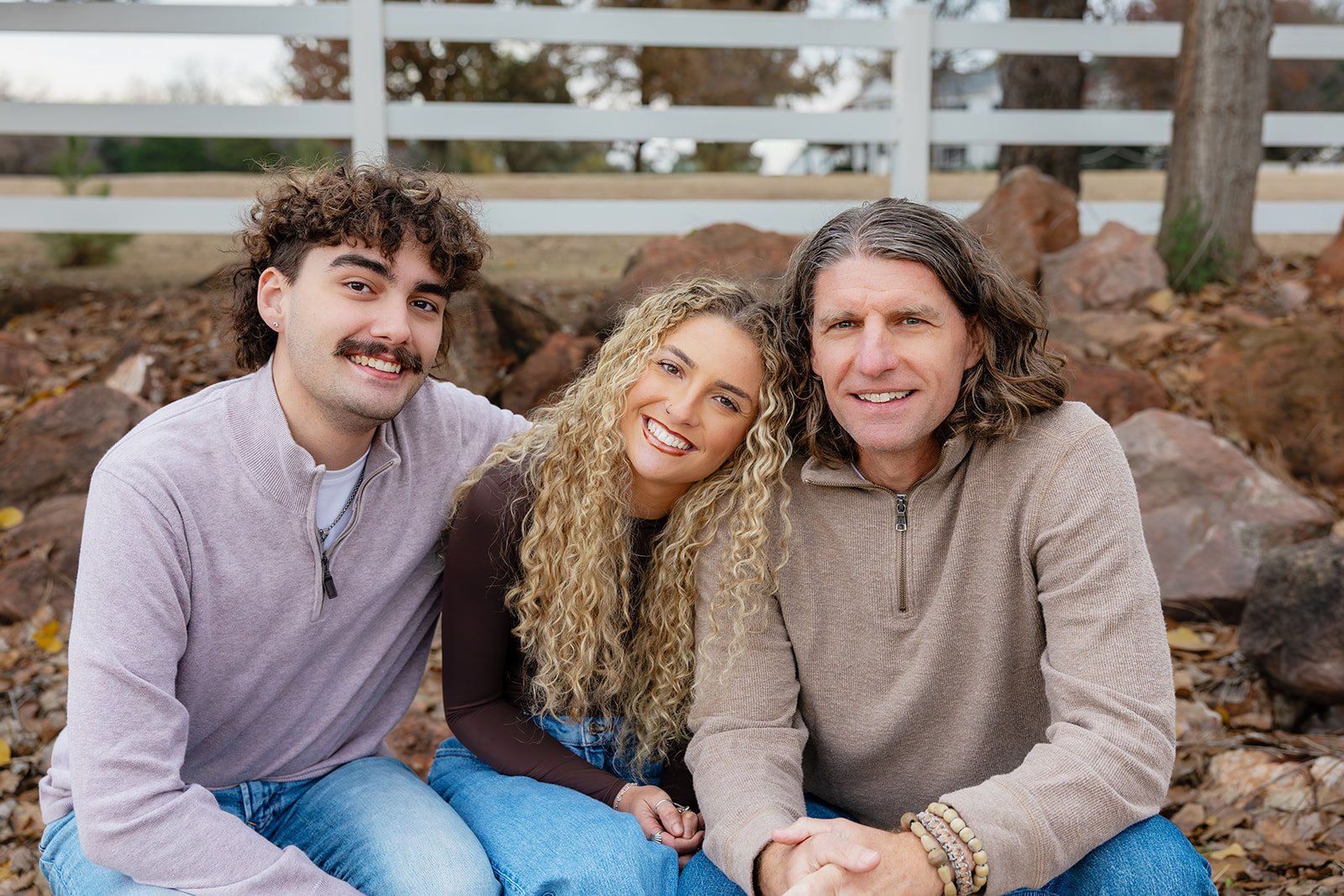 Family posing together in fall leaves for a holiday card portrait by an Oklahoma City family photographer