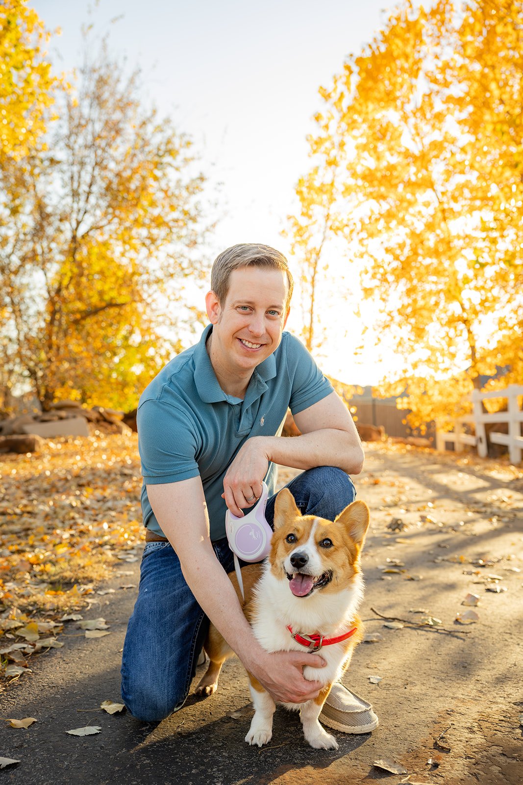 Happy dog named Penny sitting in fall leaves with her family during an outdoor photo session in Oklahoma City