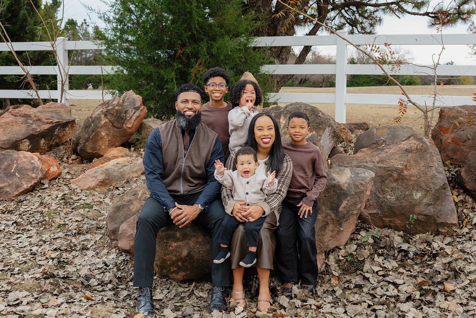 Family of six with four young boys, from a baby to a middle schooler, posing together in fall leaves in Edmond, OK