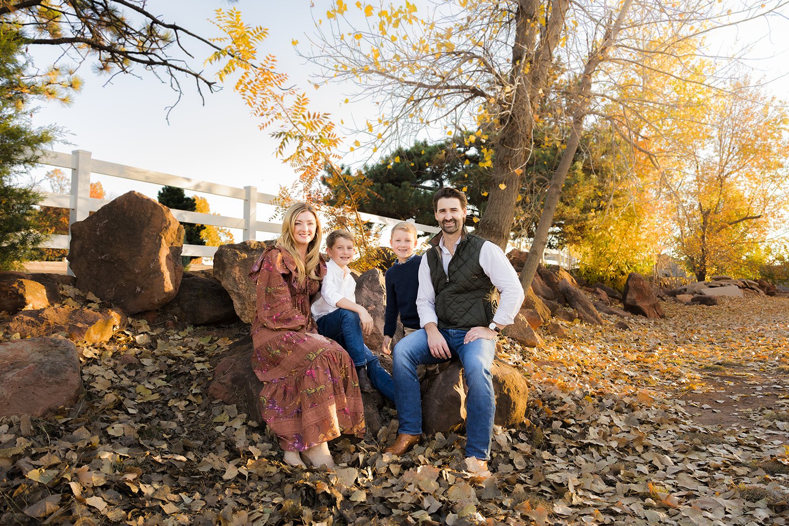 Family smiling together in warm golden hour light during fall mini sessions in Edmond, OK