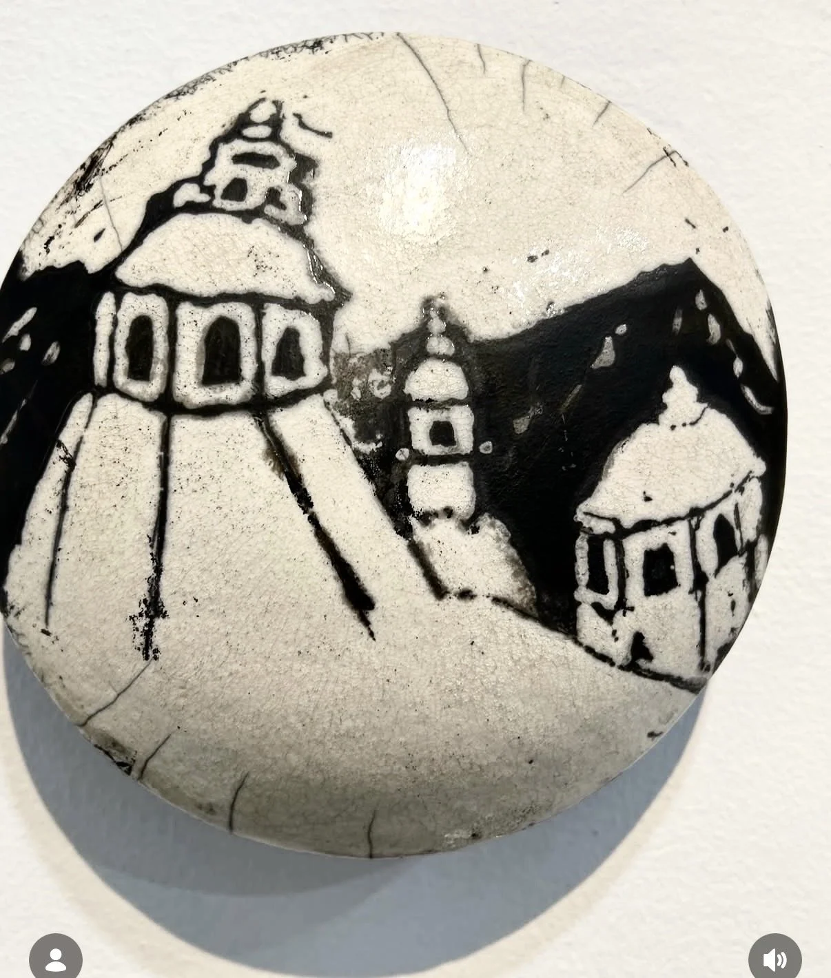 Decorative black and white stones with various patterns, arranged on a white surface.
