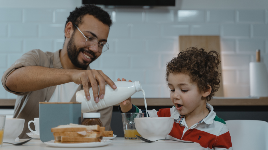 dad serving breakfast to young child