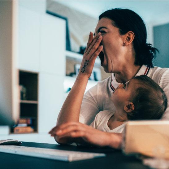 exhausted mother trying to keep up with work