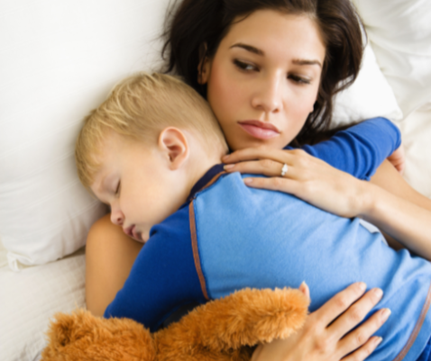 Mother cuddling child to sleep