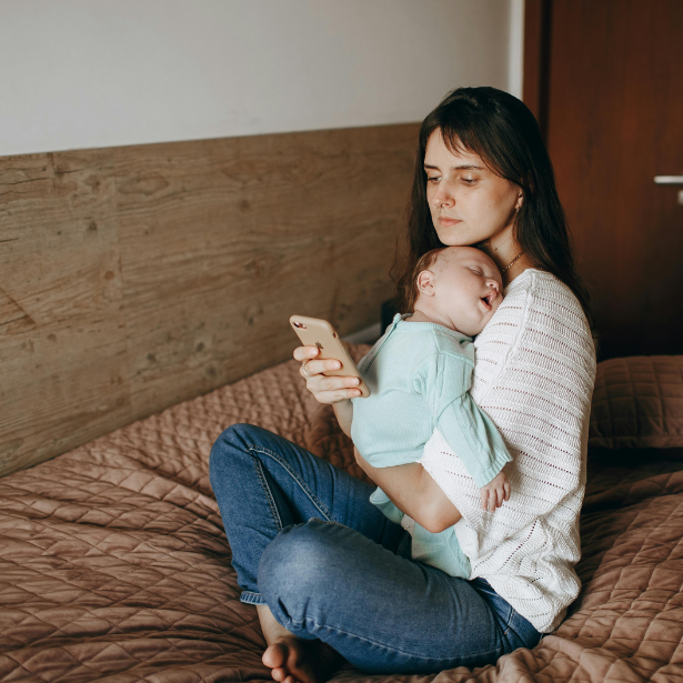 Mother with baby scrolling on her phone