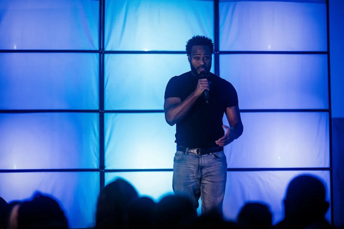 A man speaking into a microphone on a stage