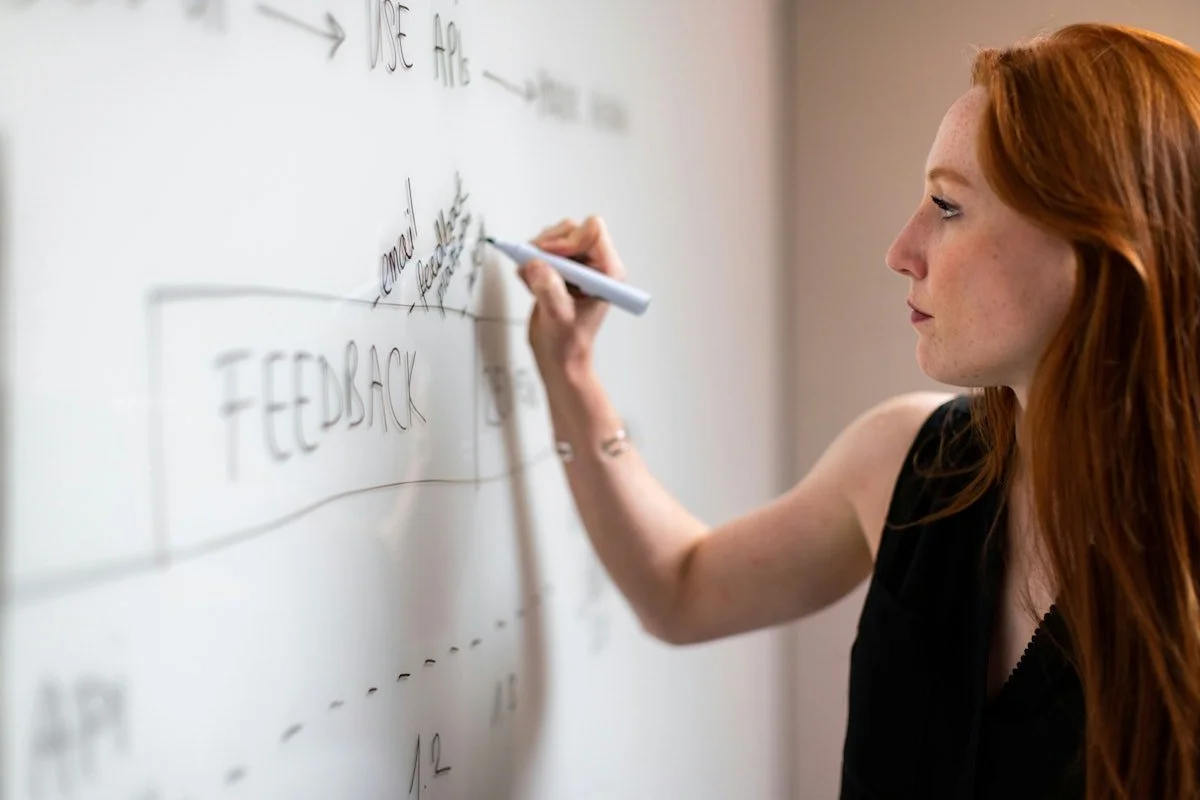 Woman in black shirt holding white marker