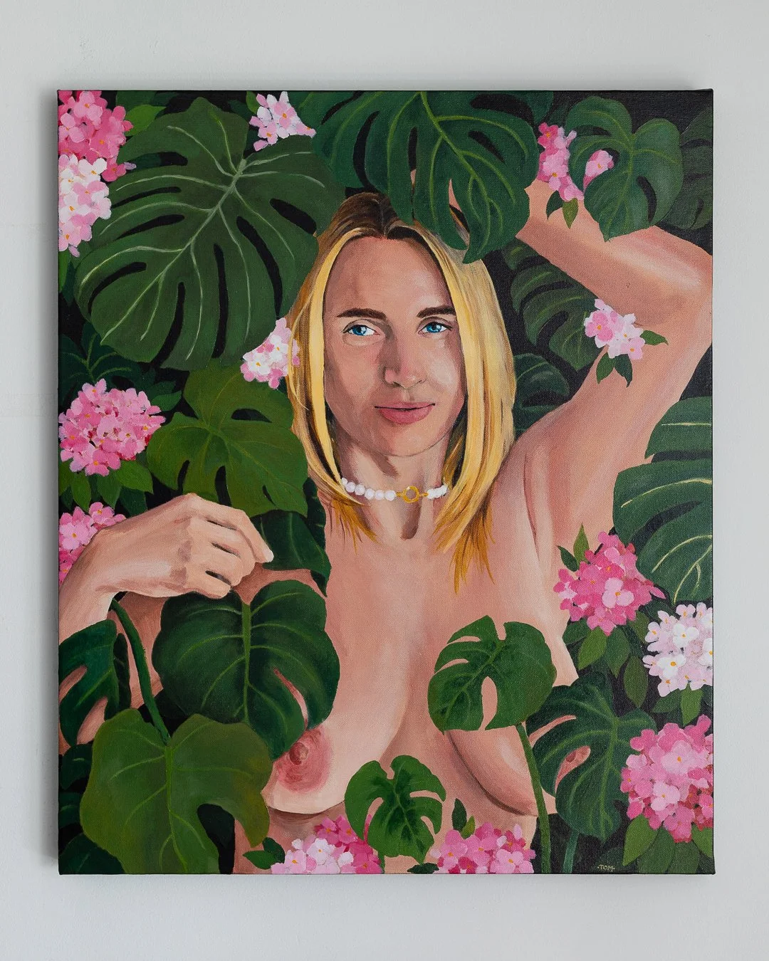 A painting of a woman with blonde hair and blue eyes surrounded by large green leaves and pink flowers, holding a leaf near her face and wearing a pearl necklace.