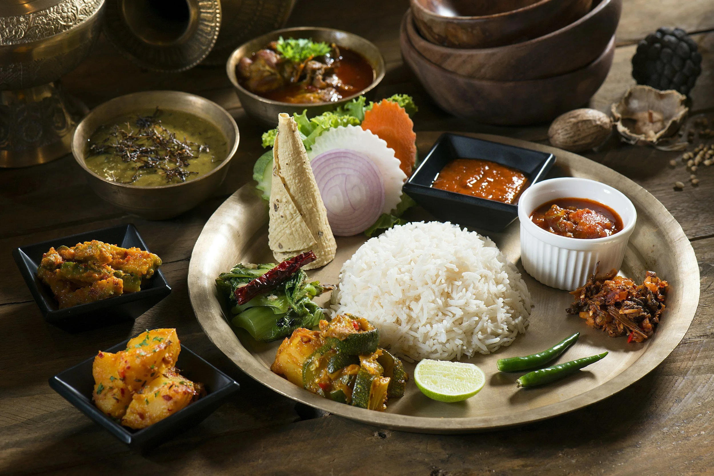 Traditional Nepali dal bhat served with lentil soup, rice, seasonal vegetables, and pickles.