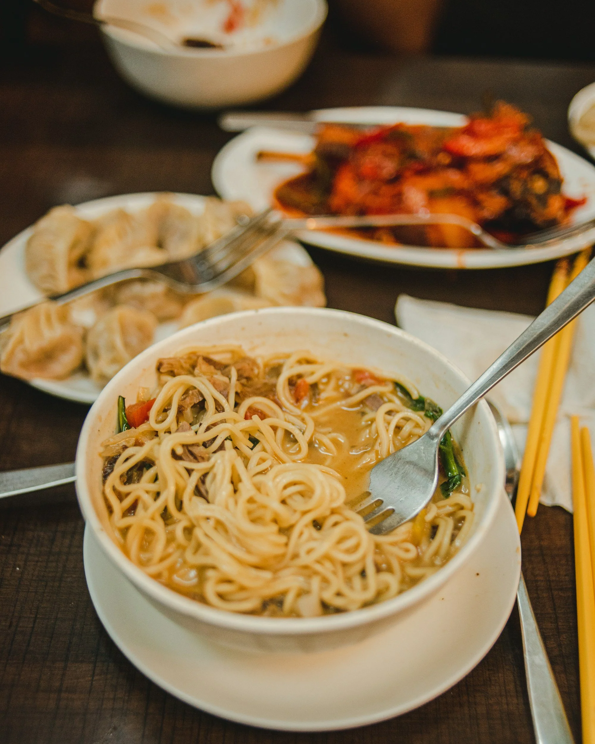 A bowl of Nepali thukpa, a traditional noodle soup with vegetables and herbs.