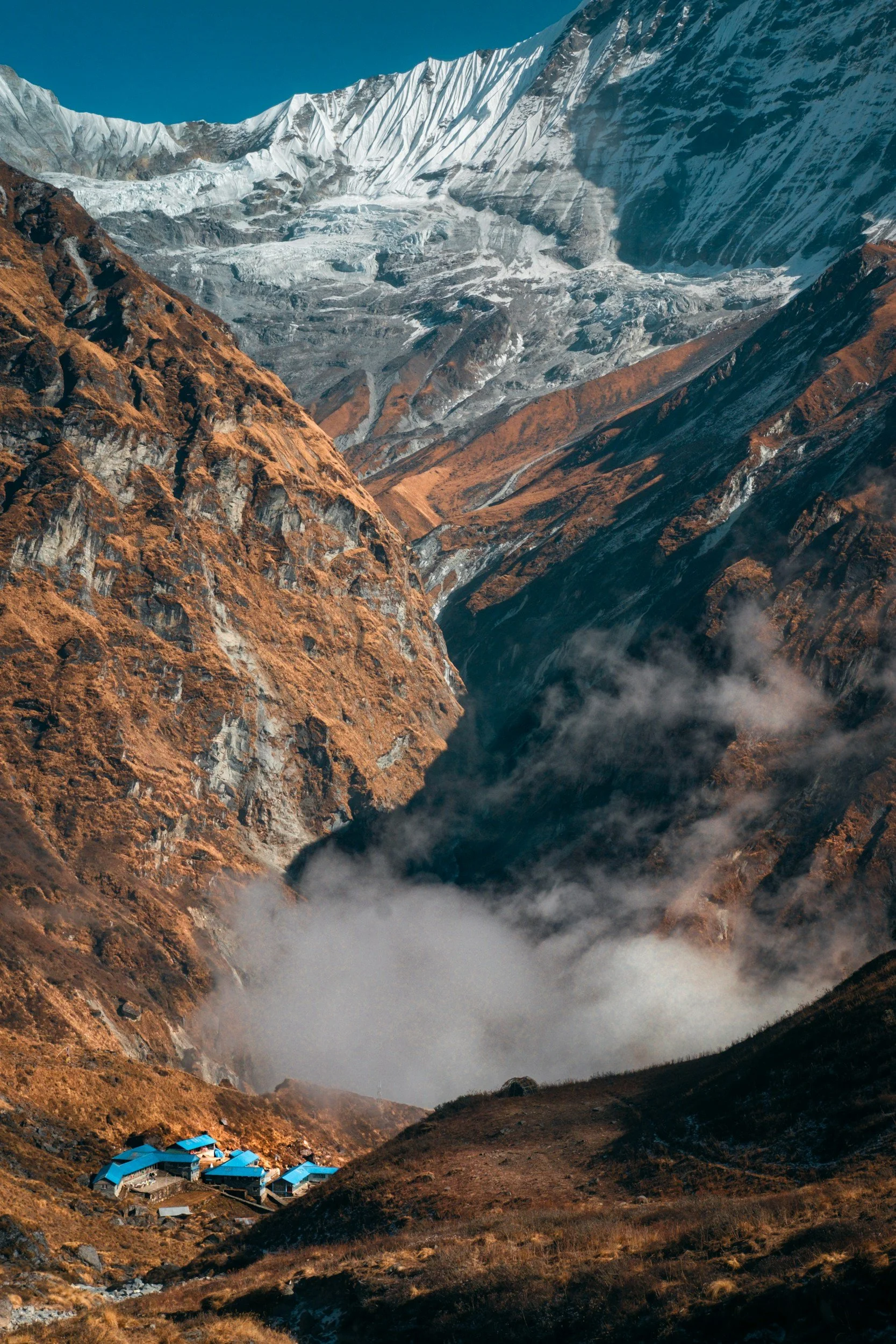 Machhapuchhare Base Camp with prayer flags and surrounding Himalayan peaks in the Annapurna region of Nepal