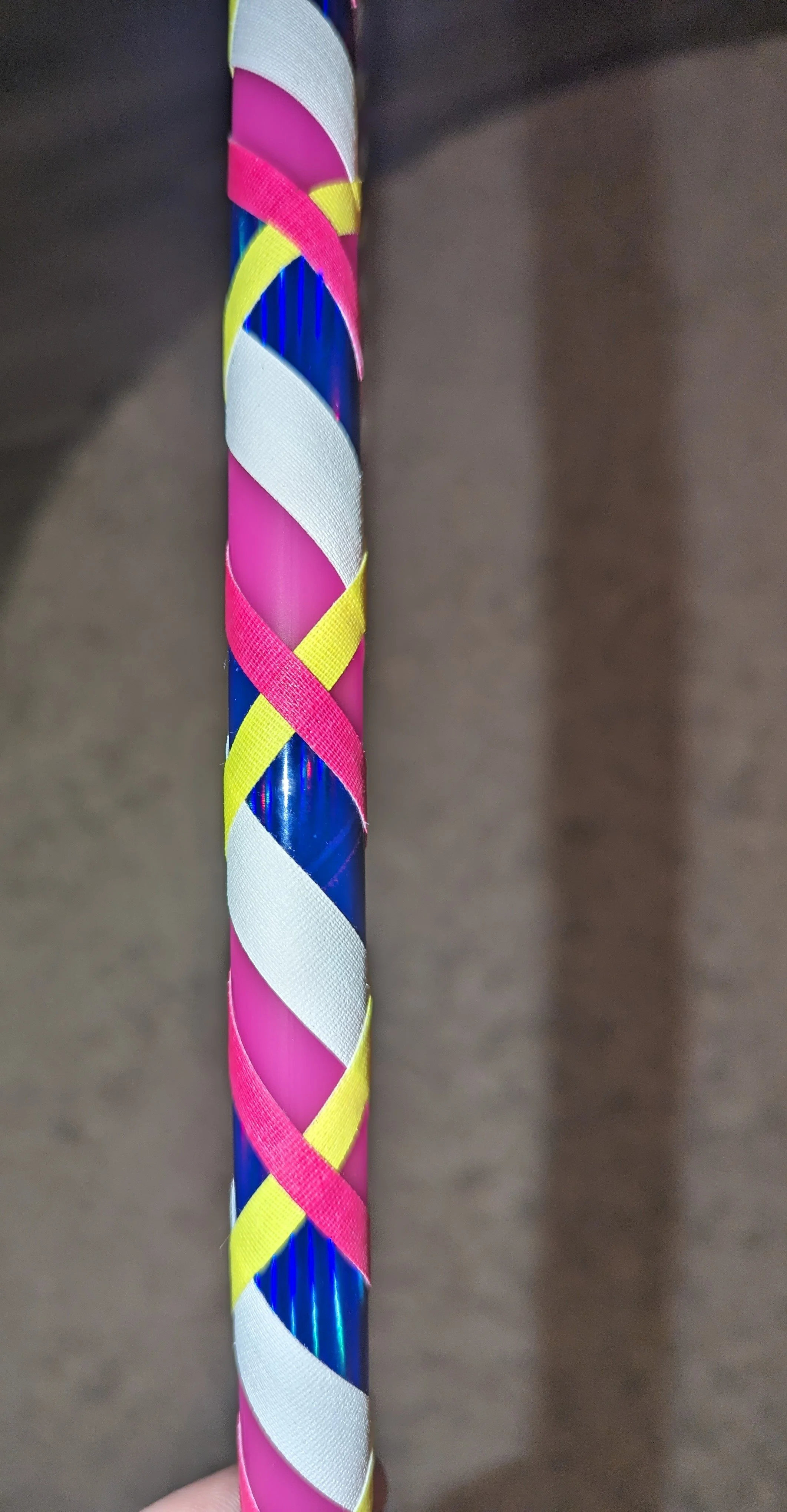 Bunter Stock mit schrägen, gewickelten Streifen in Pink, Weiß, Gelb und Blau.