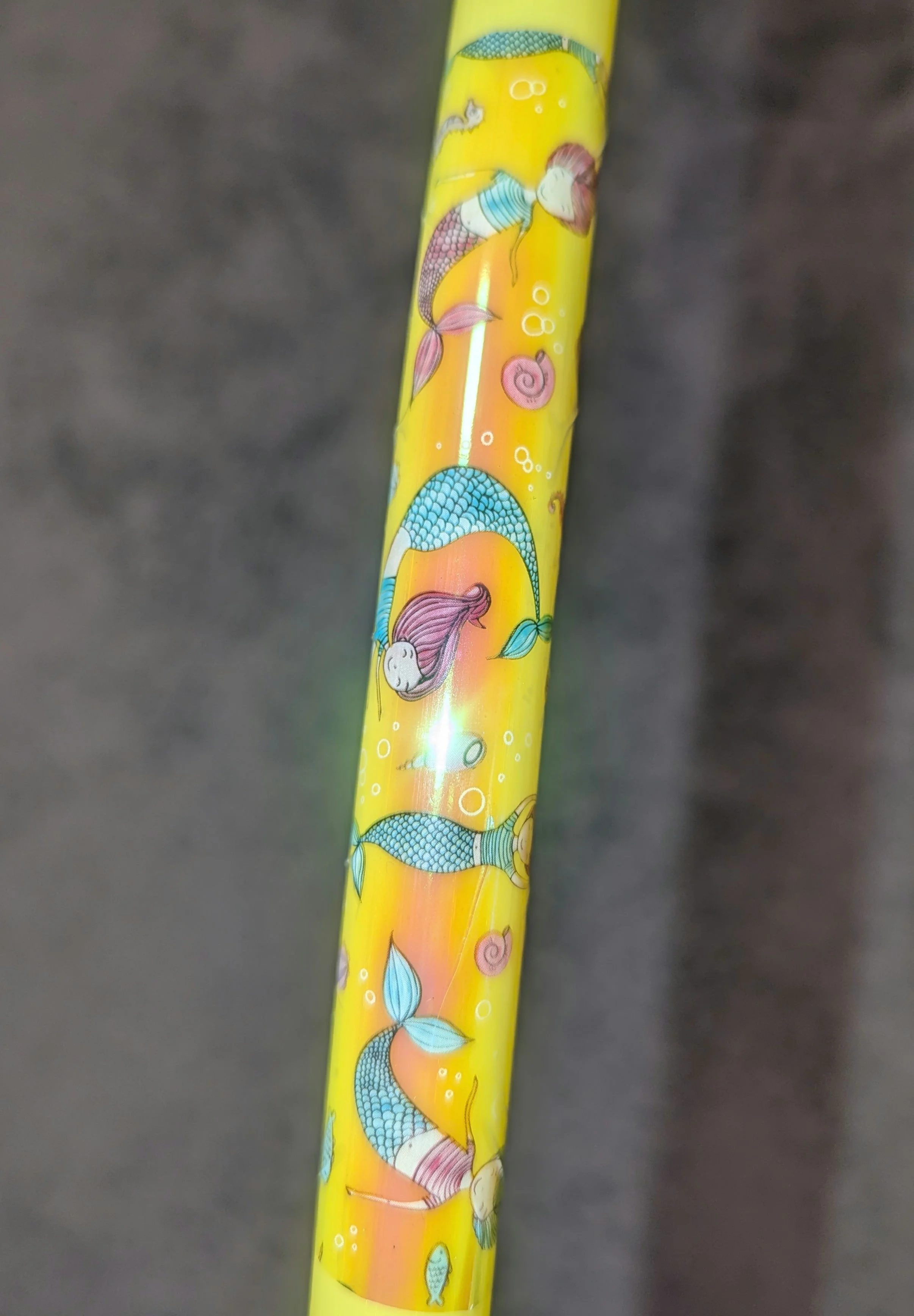 Gelber Stift mit Meerjungfrauenmuster und Muscheln verziert.