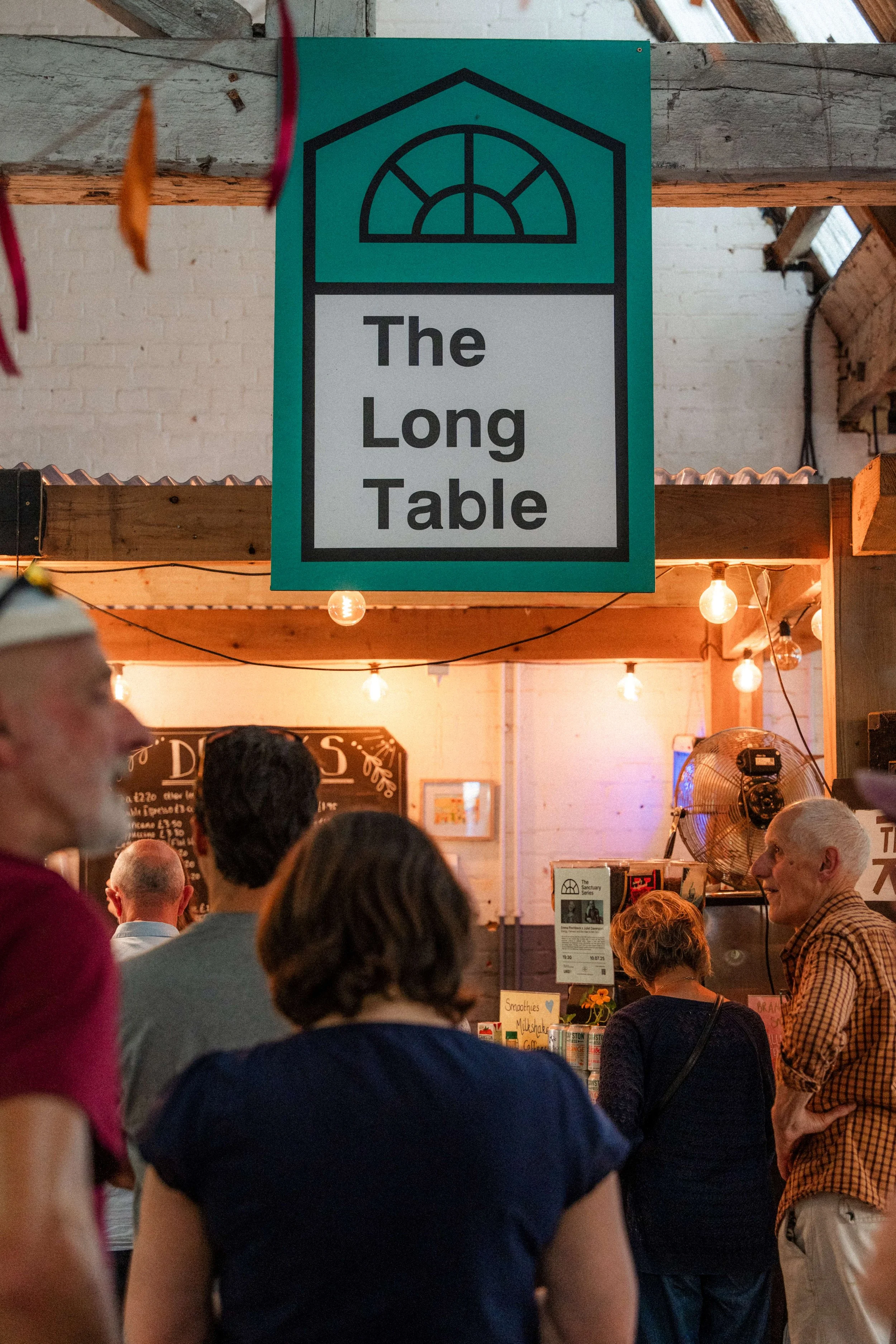 a restaurant with people queuing at a bar
