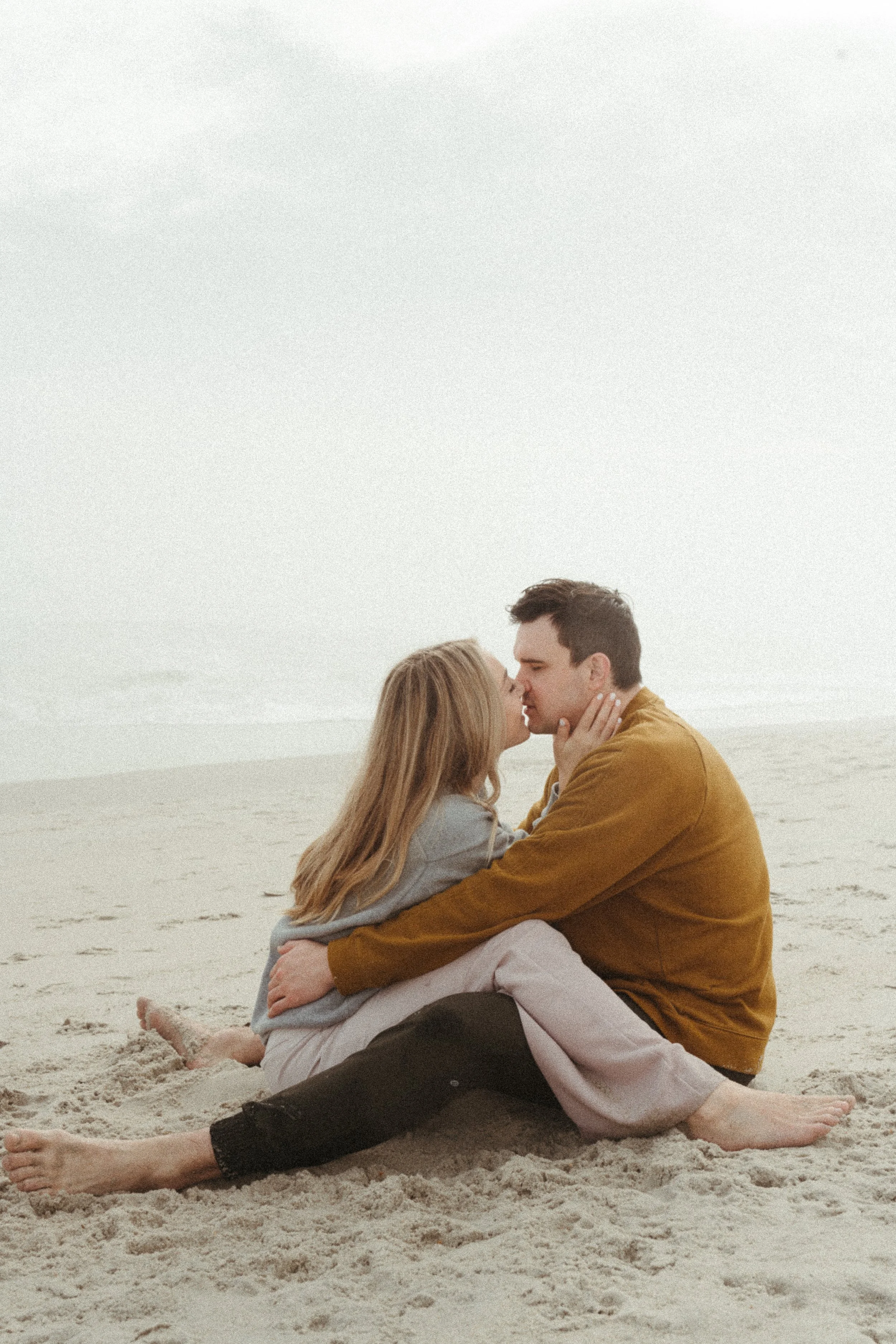 a couple loves on one another on a beach
