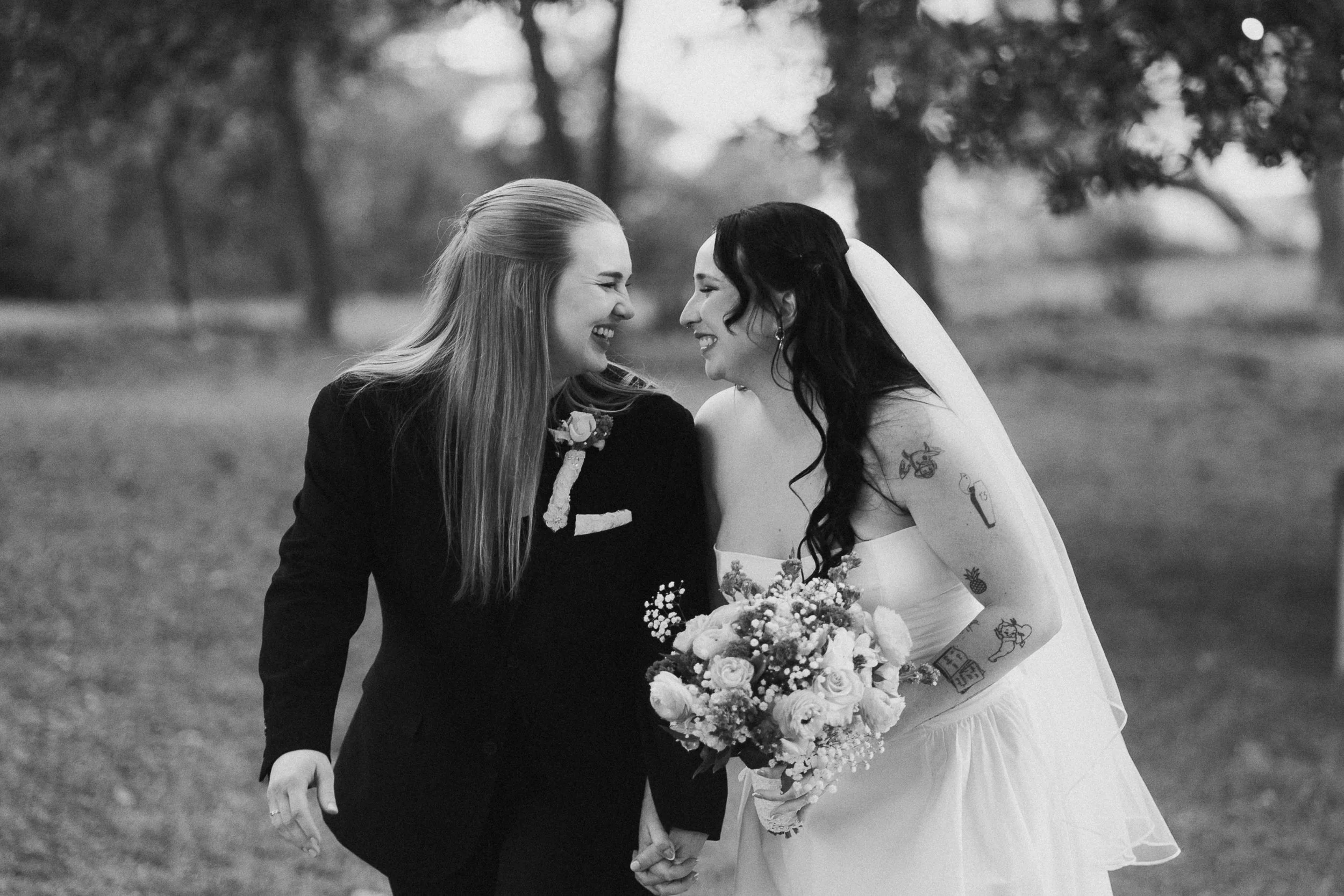 Two brides celebrating their wedding beneath a huge oak tree draped in café lights at a cozy Airbnb by the Masonboro Channel in North Carolina | intimate LGBTQ+ wedding with a loving, supportive family