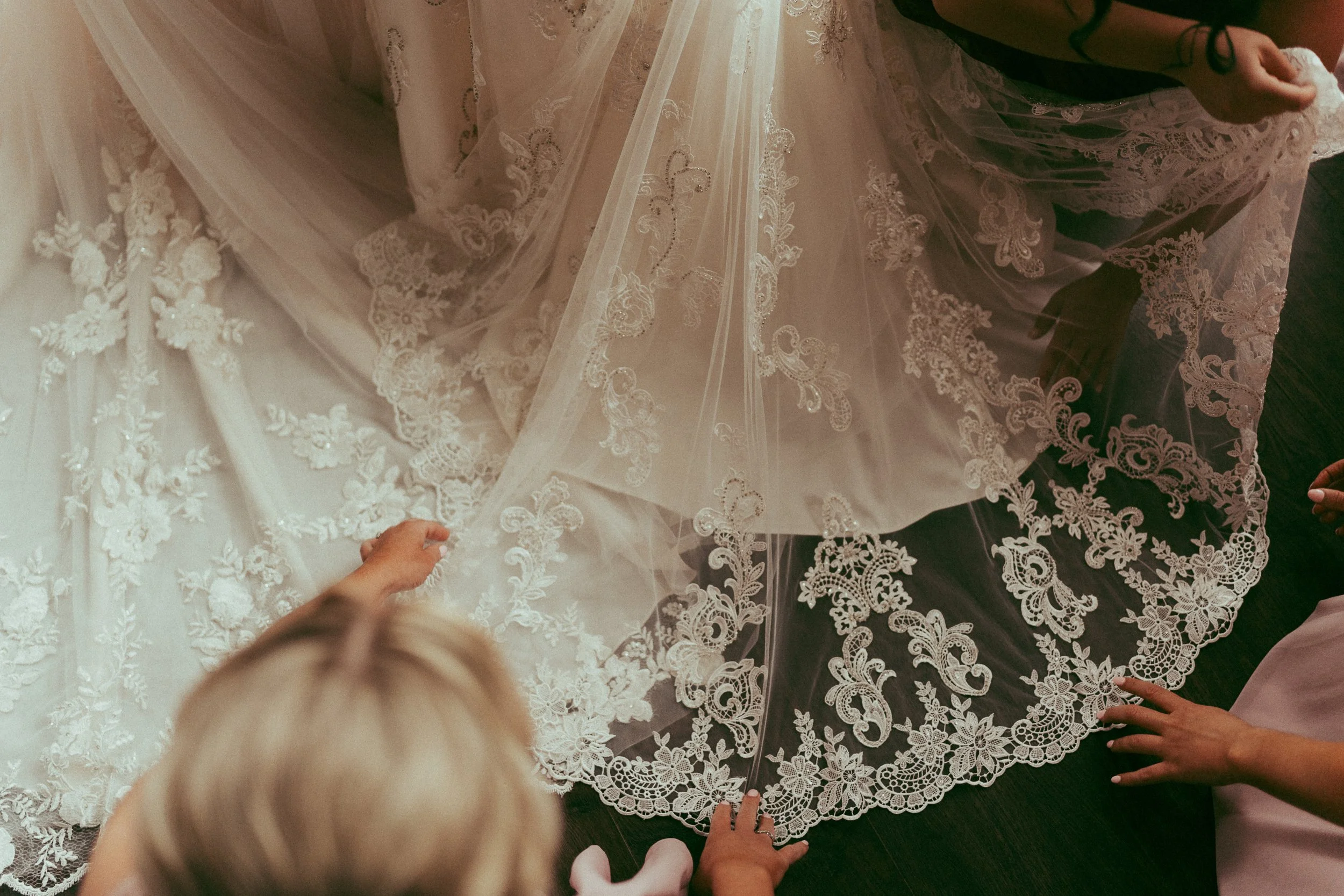 Bridesmaids adjusting their dresses while standing side by side before a same-sex wedding ceremony at the Legacy Club in Cherry Hill, NJ | candid LGBTQ+ wedding photography in color