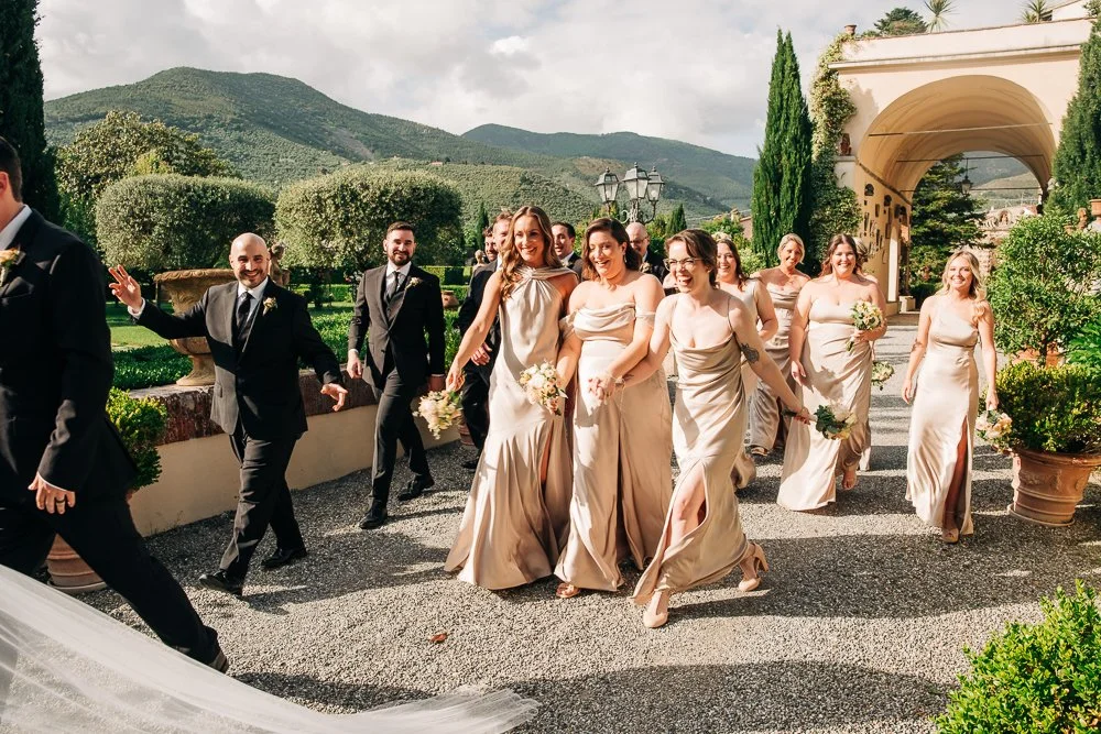 bridesmaids and groomsmen laugh as they walk to cocktail hour at a destination wedding