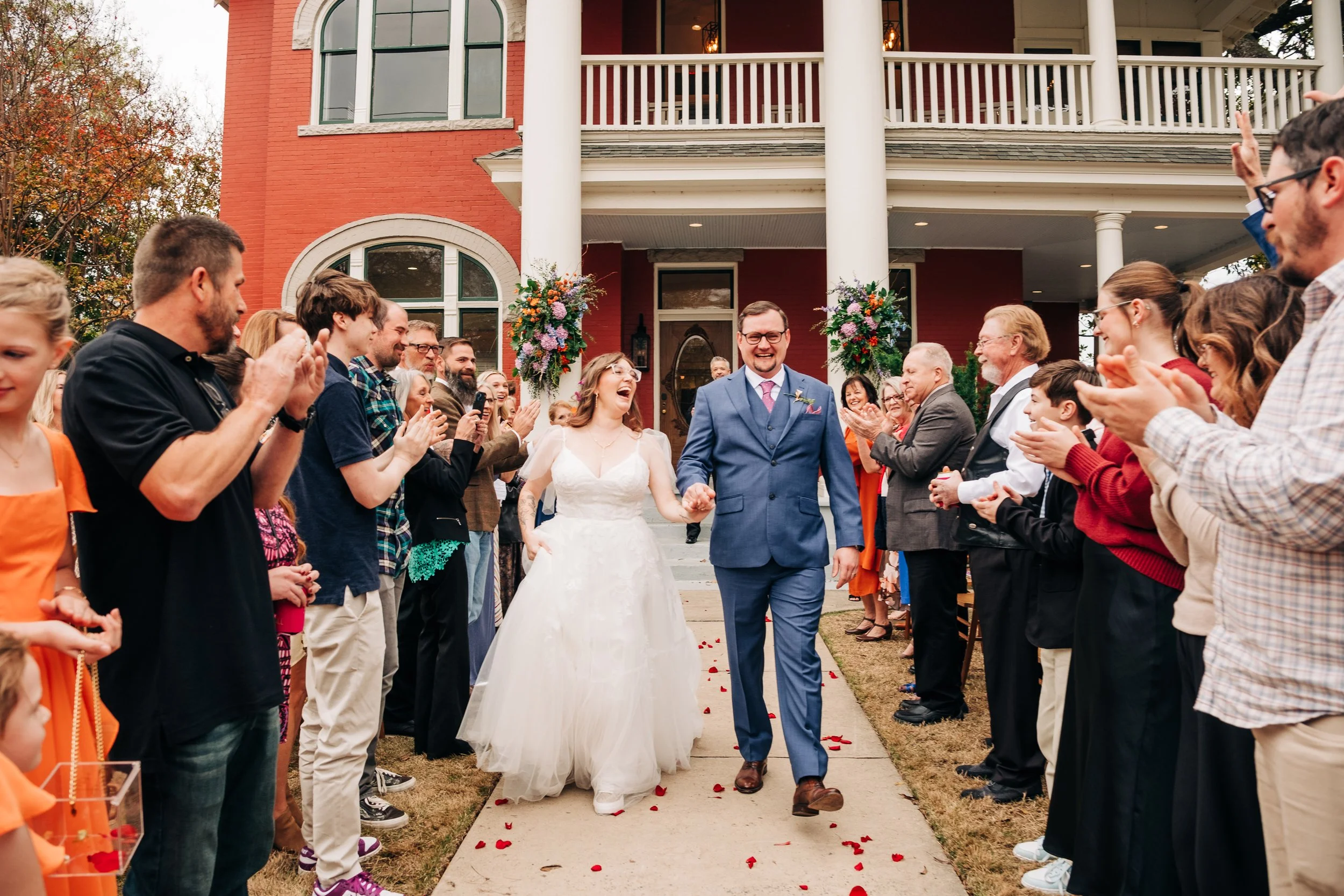 A couple walks down the aisle seconds after being pronounced married. Candid moment caught by West Michigan wedding photographer Libby Dollar