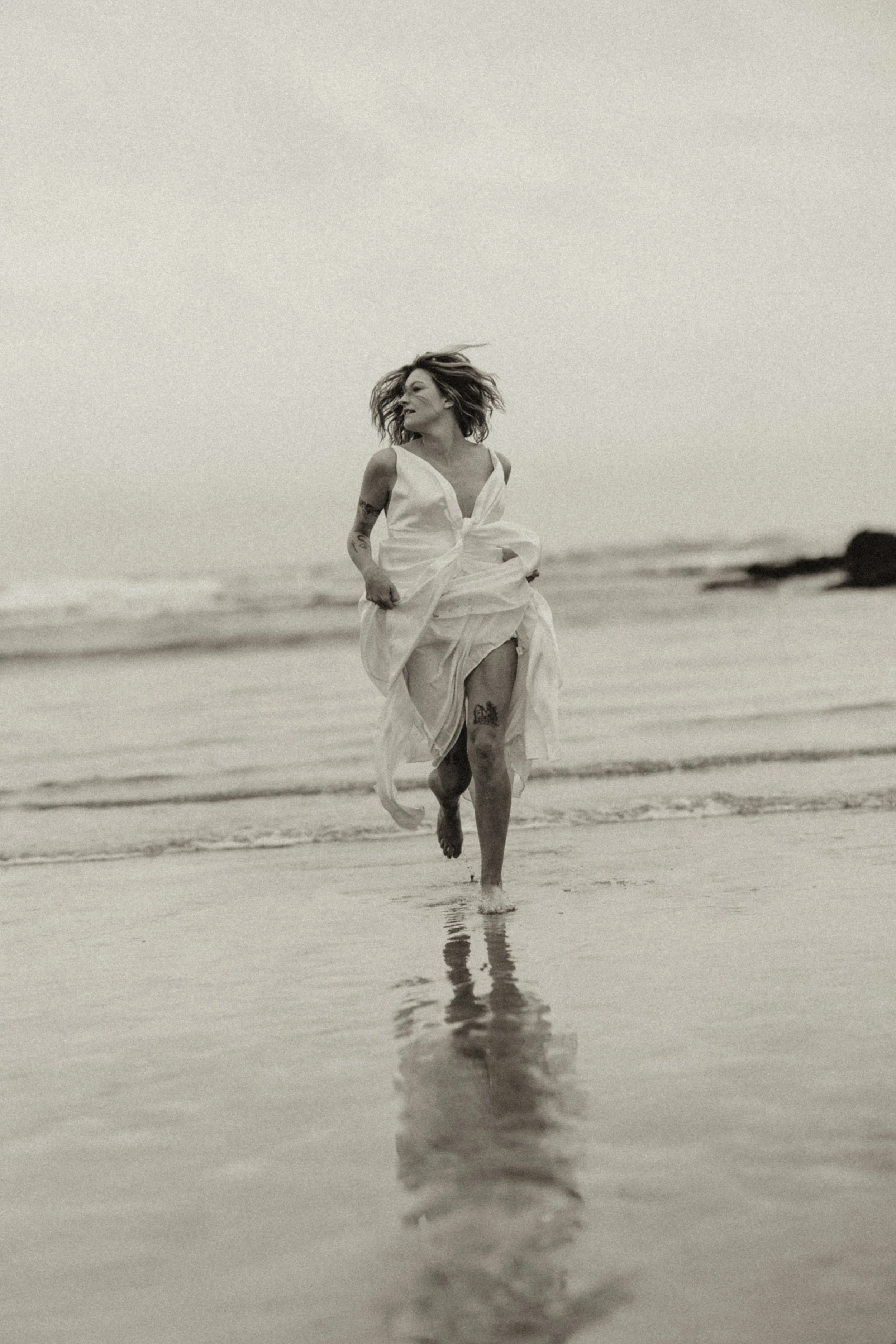 Bride in motion on a Cornwall beach with a relaxed, effortless feel