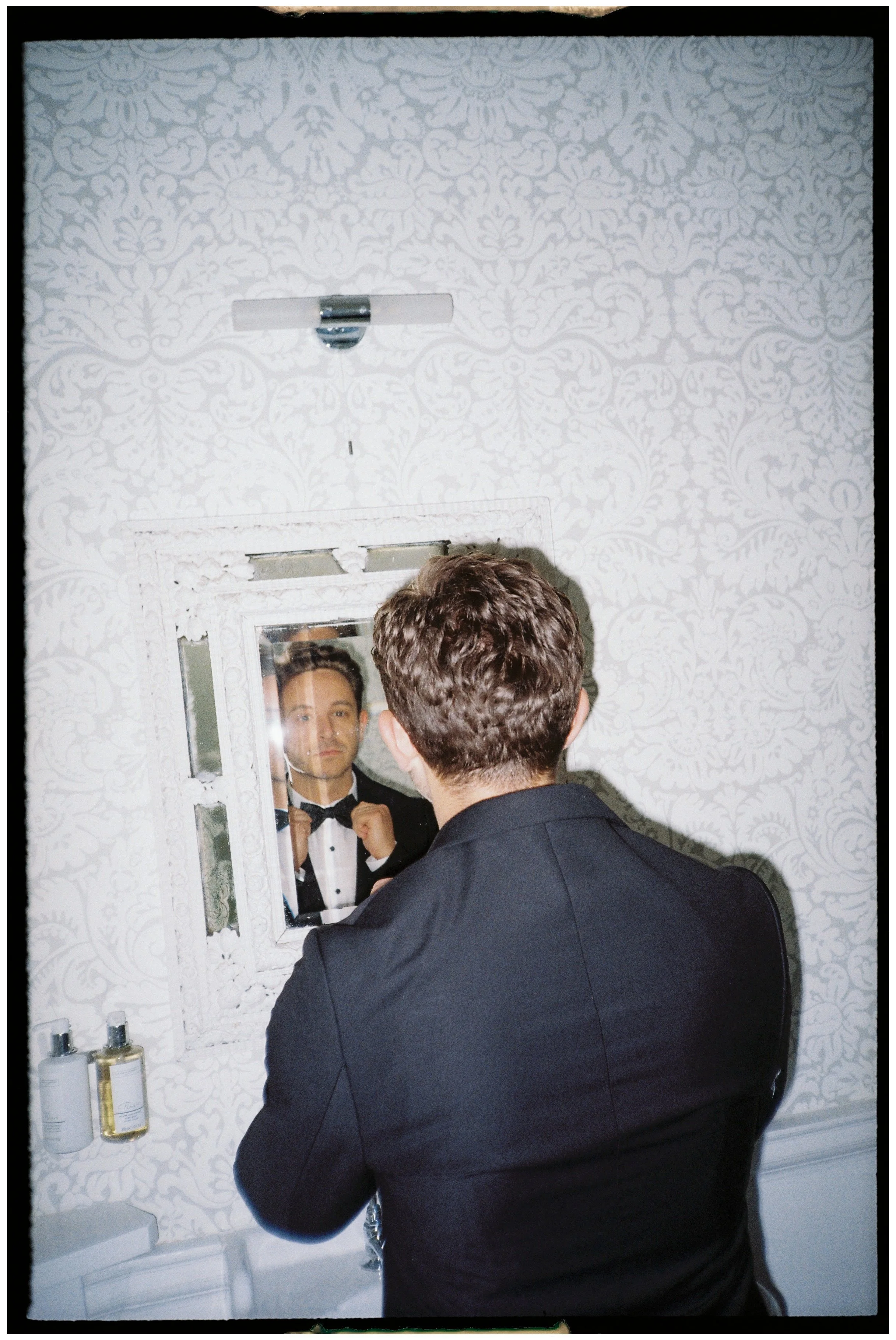  Groom portrait on 35mm film with relaxed, candid expression and soft contrast 