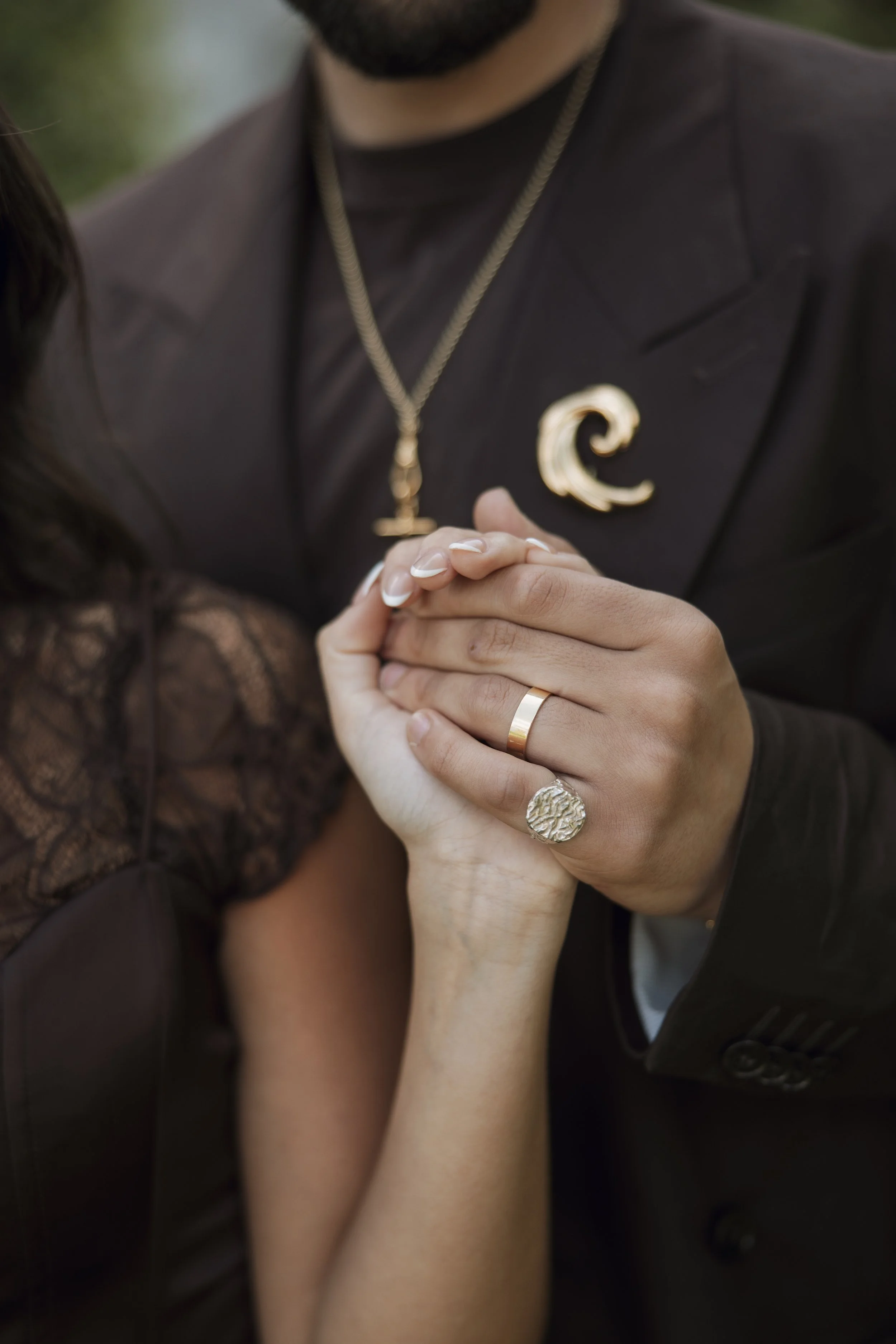 Close-up of a couple’s hands intertwined, showcasing rings and jewellery during an editorial pre-wedding shoot in Biarritz.