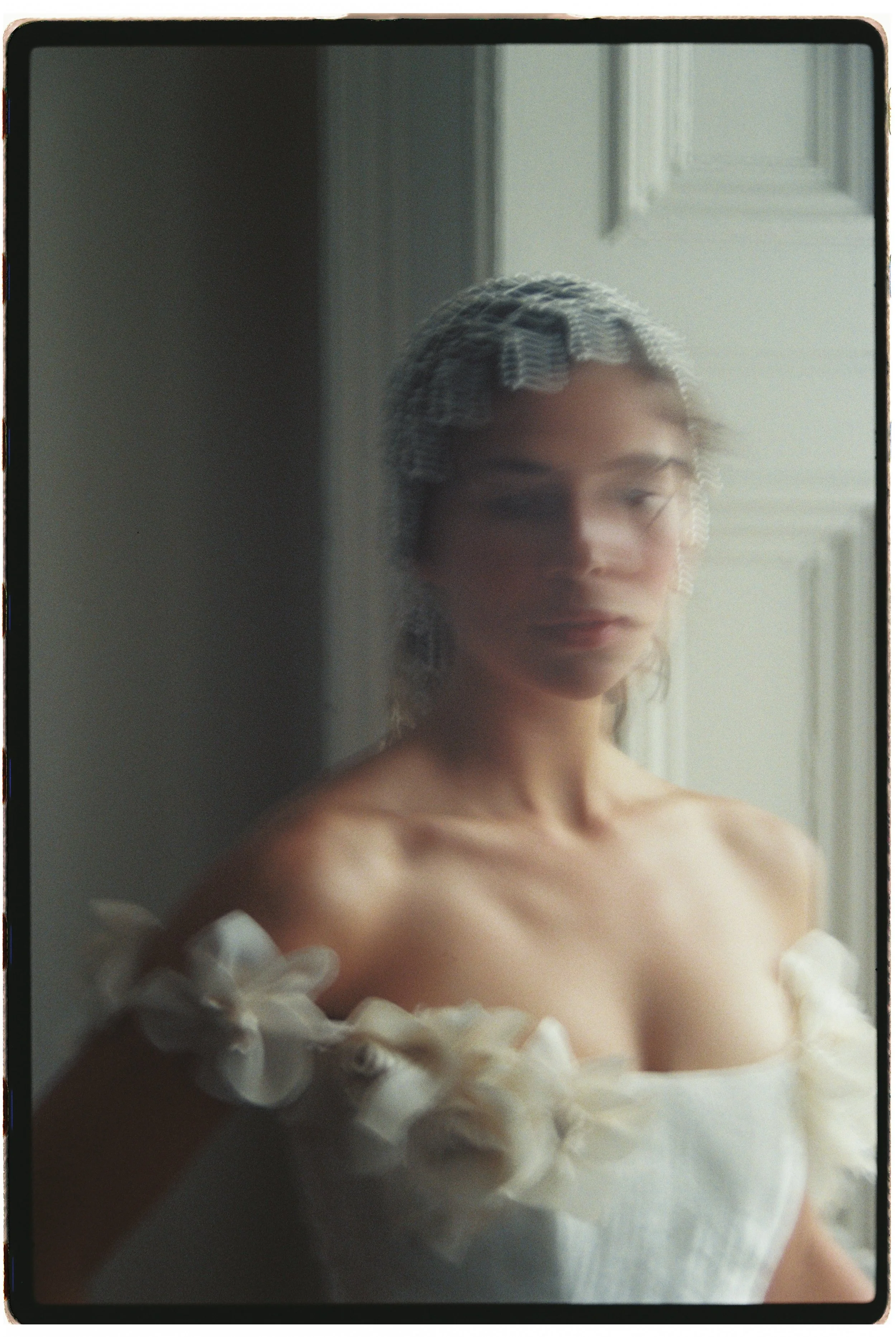 ditorial bridal portrait photographed on film, featuring a contemporary wedding gown, beaded headpiece and soft natural light